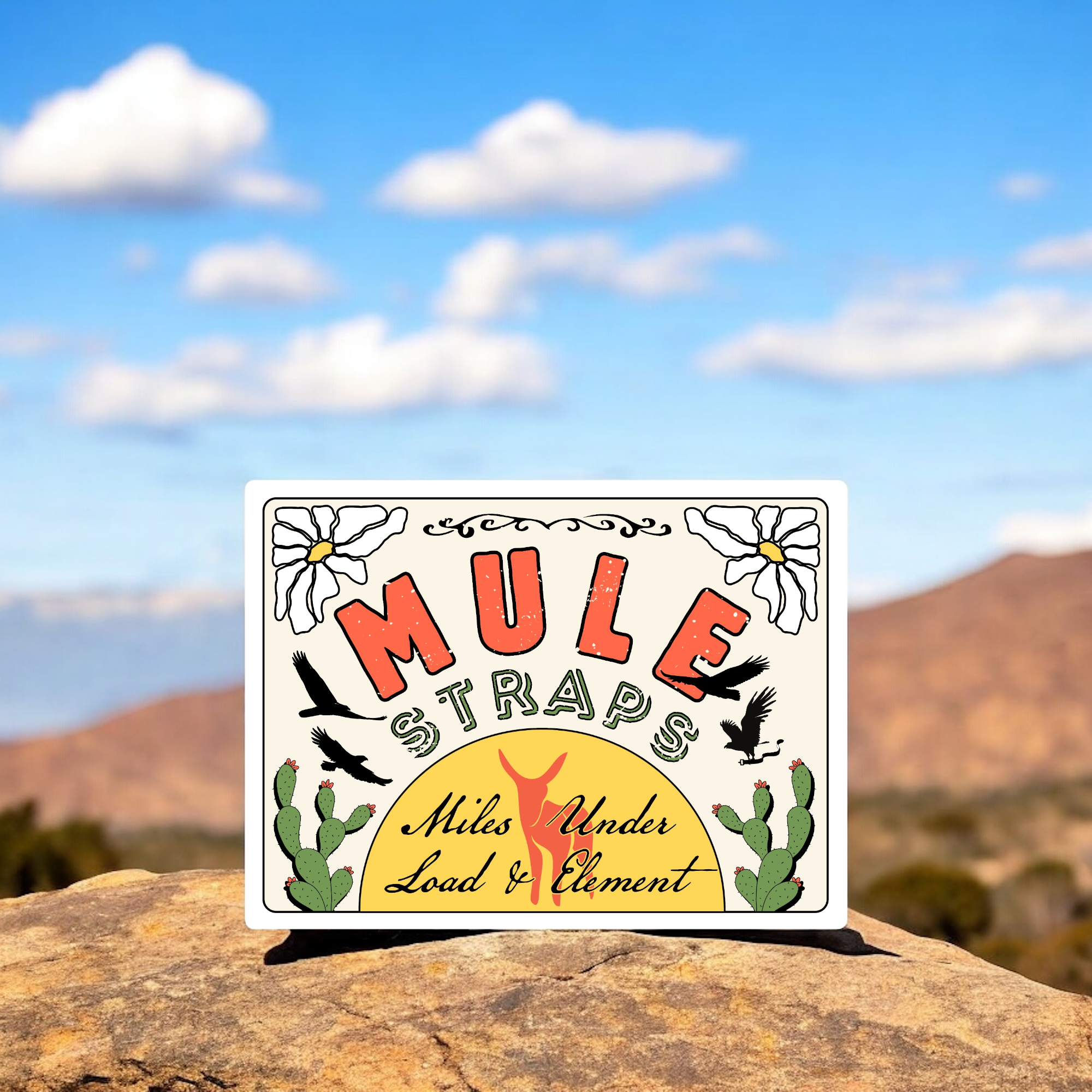 MULE Straps illustrated label with “Miles Under Load & Element” tagline, set against desert rocks and blue sky.
