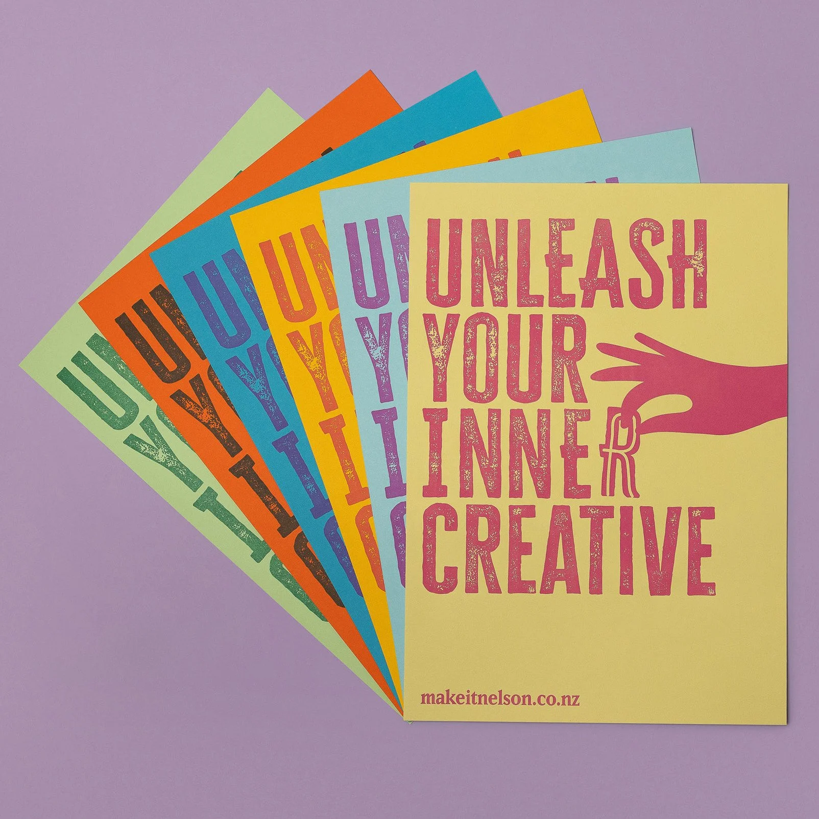 A fan of Make It Nelson letterpress posters printed in green and pink inks on brightly coloured paper stocks.
