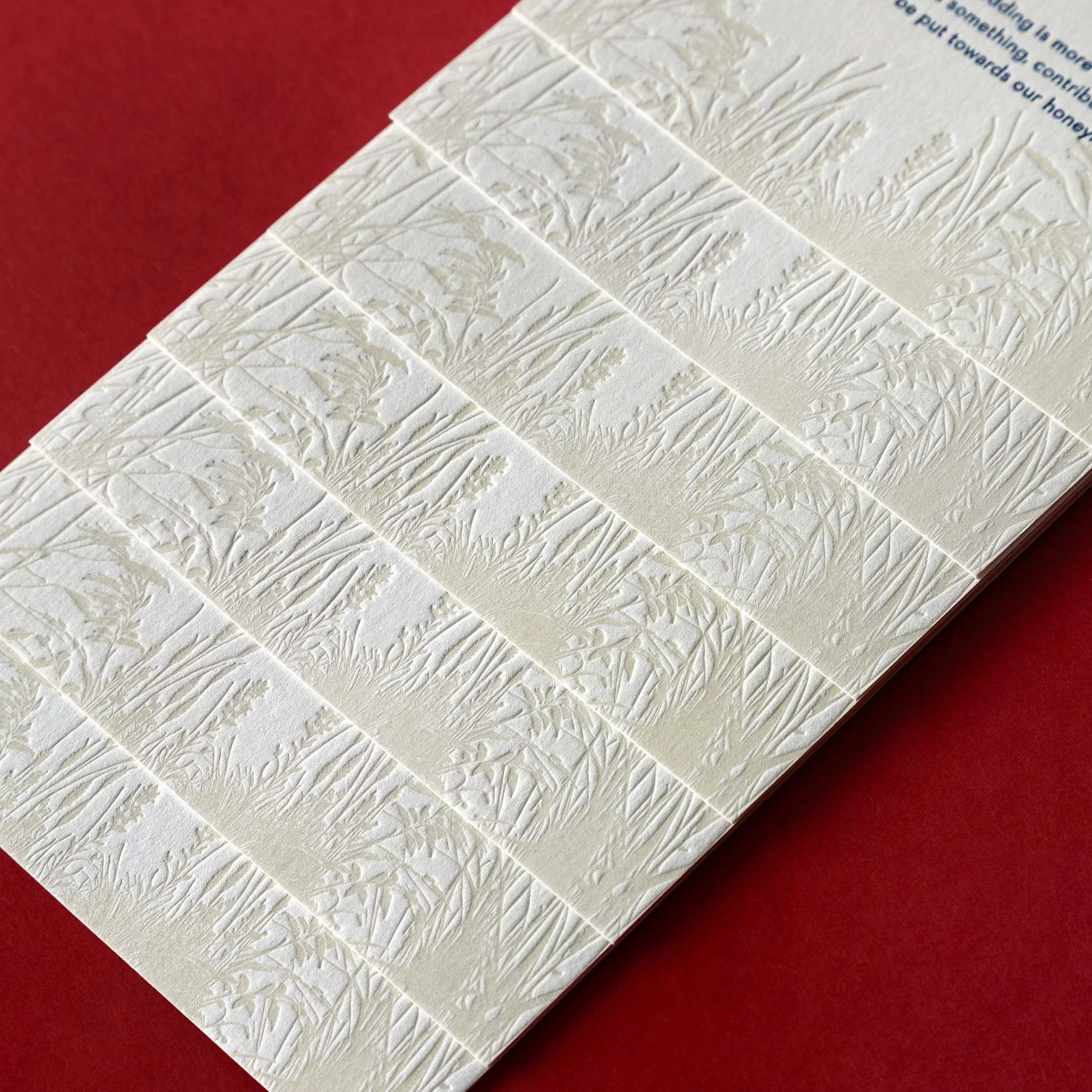 Close-up of the tactile letterpress tussock grass illustration on Brontë and Simon’s Boomrock details card.