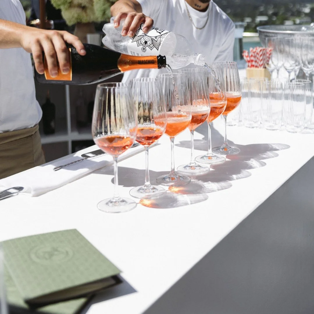 Angela and Justin’s wedding bar at Putiki Estate, with custom green bar menus alongside drinks being prepared for guests.