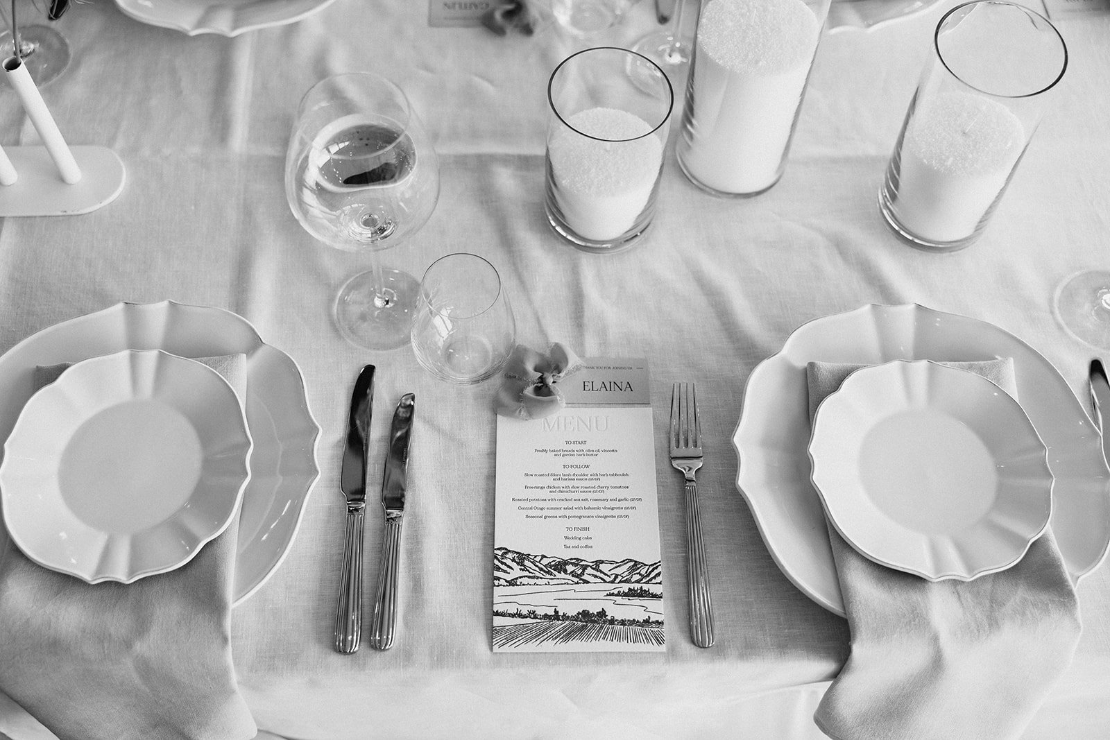Letterpress wedding menu featuring a hand-drawn landscape illustration at a guest place setting at Rippon, Wānaka.