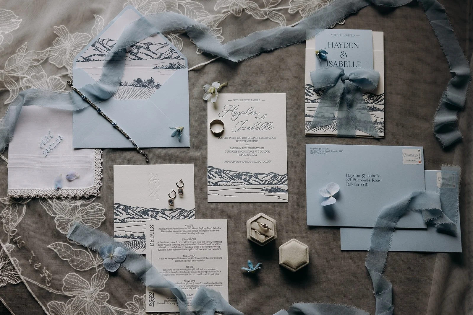 Styled wedding invitation suite featuring a letterpress invitation, details card, envelope and hand-drawn landscape illustration inspired by Rippon in Wānaka.