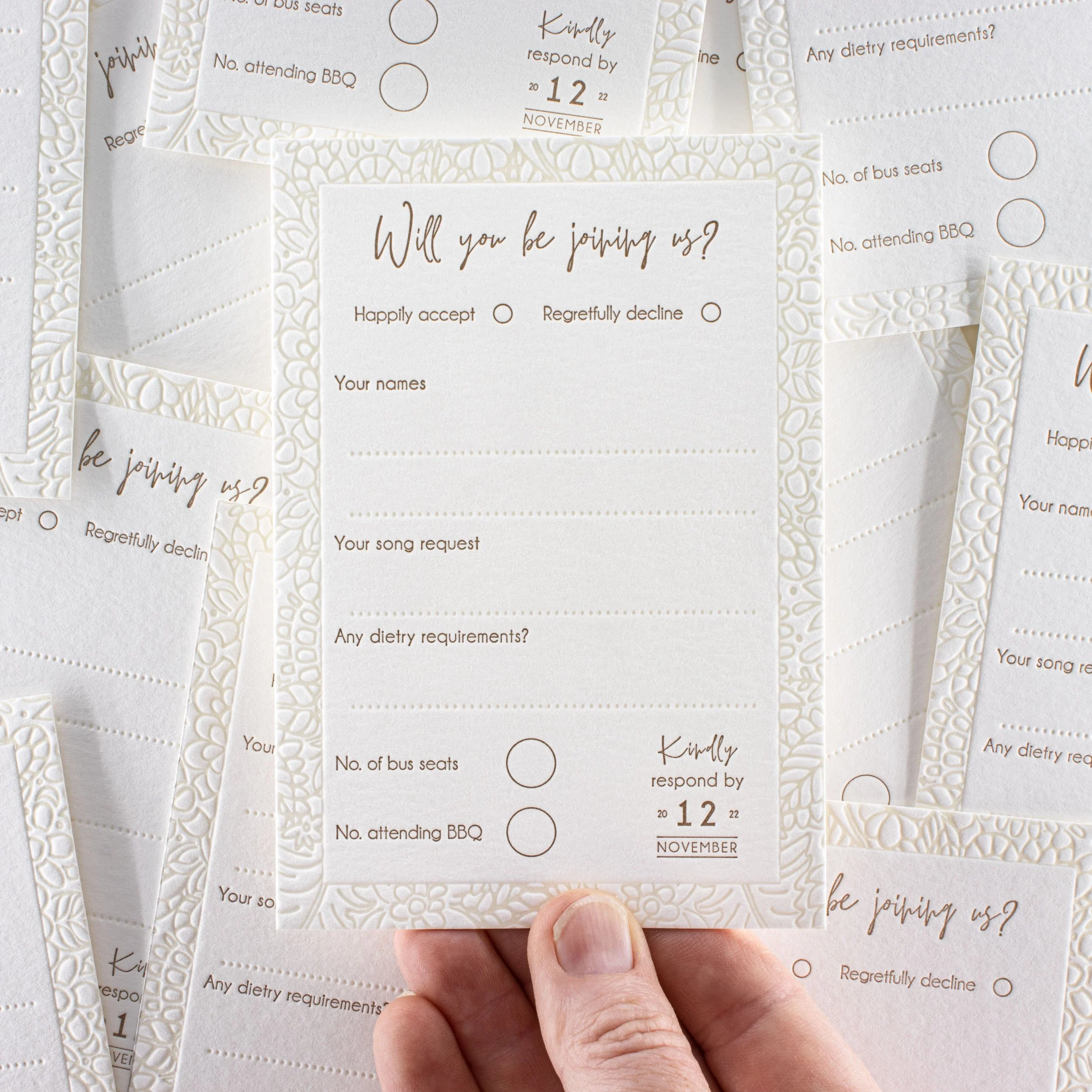 Emma and Hayden’s RSVP card with a deeply impressed letterpress floral border, warm gold typography and personalised response details.