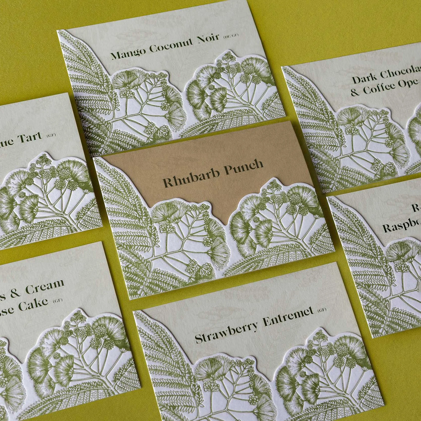 Greer and Cohen’s wedding dessert and drinks signs featuring die-cut letterpress silk flower illustrations layered over textured card.