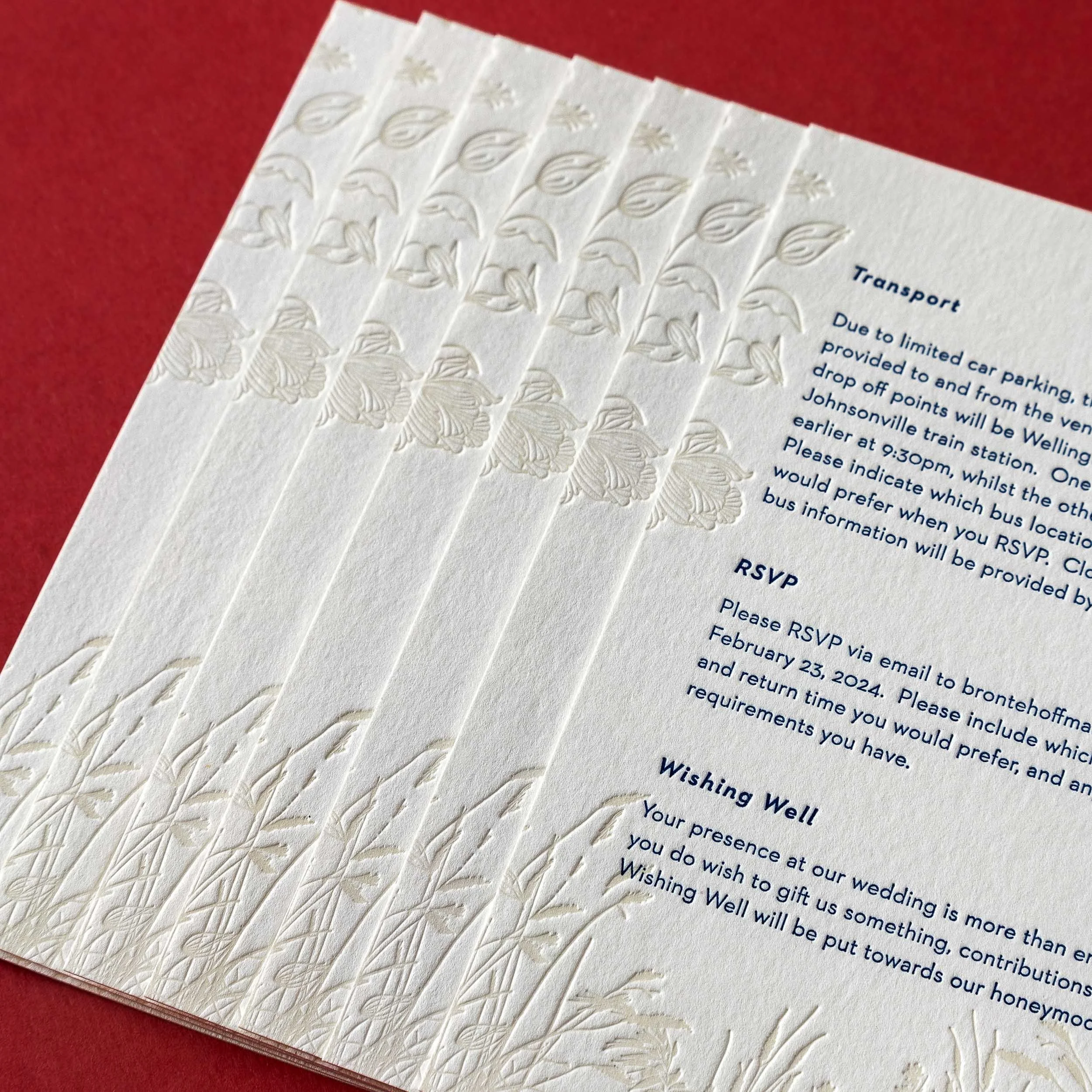Close-up of Brontë and Simon’s letterpress details card, with deep blue typography and tactile tussock grass illustrations inspired by Boomrock.