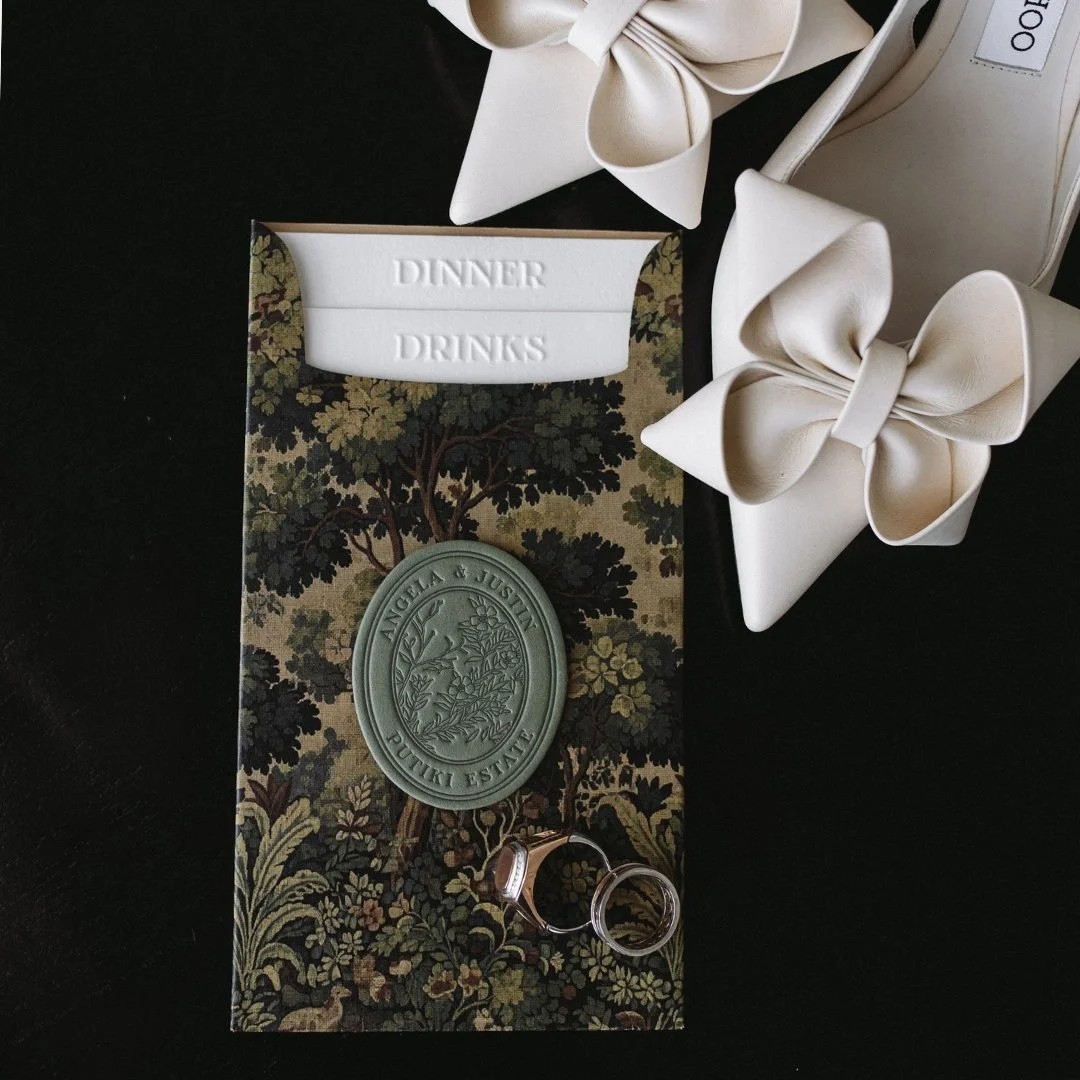 Angela and Justin’s wedding menu enclosure featuring richly detailed tapestry artwork, a custom wedding crest and blind embossed menu tabs.