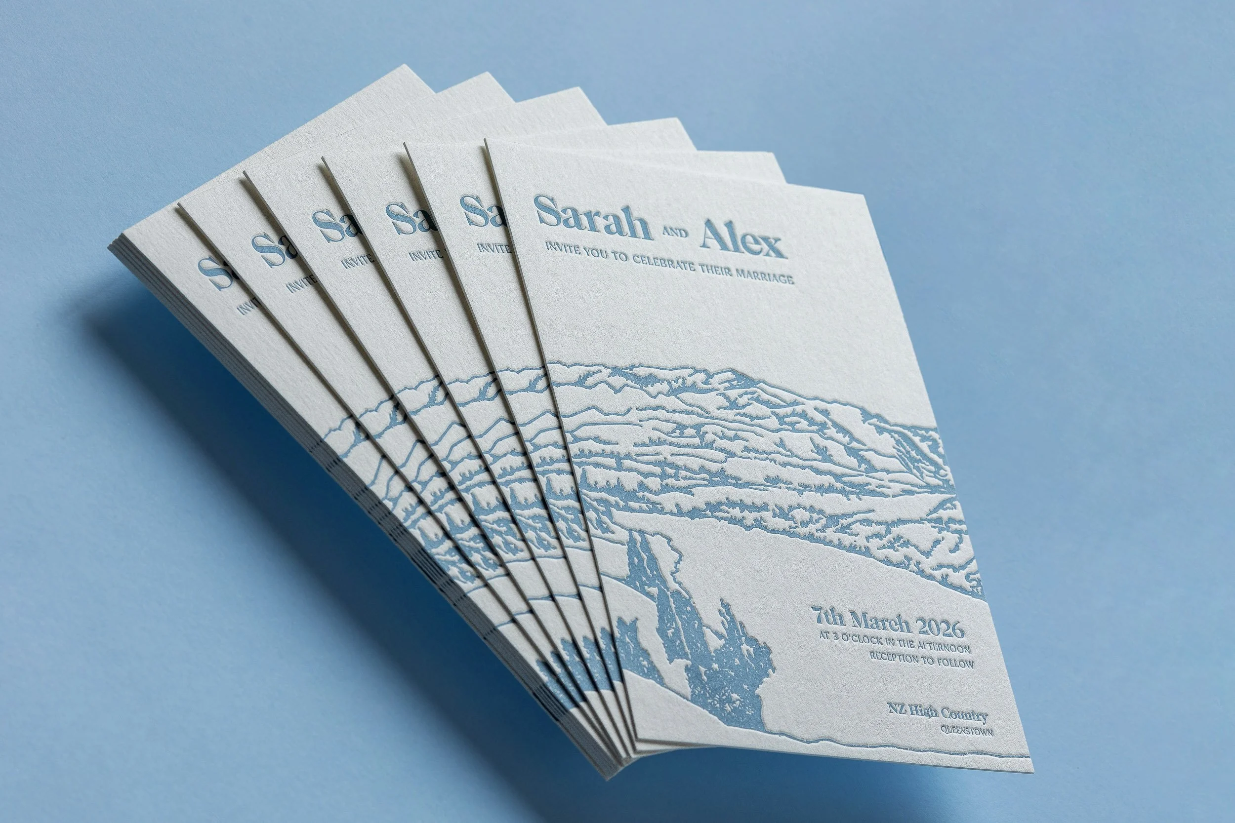Blue letterpress wedding invitations featuring a Coronet Peak landscape illustration on thick cotton paper.