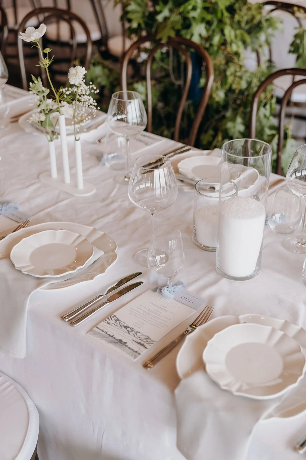 Letterpress wedding menu displayed at a guest place setting at Rippon in Wānaka, featuring a hand-drawn landscape illustration.