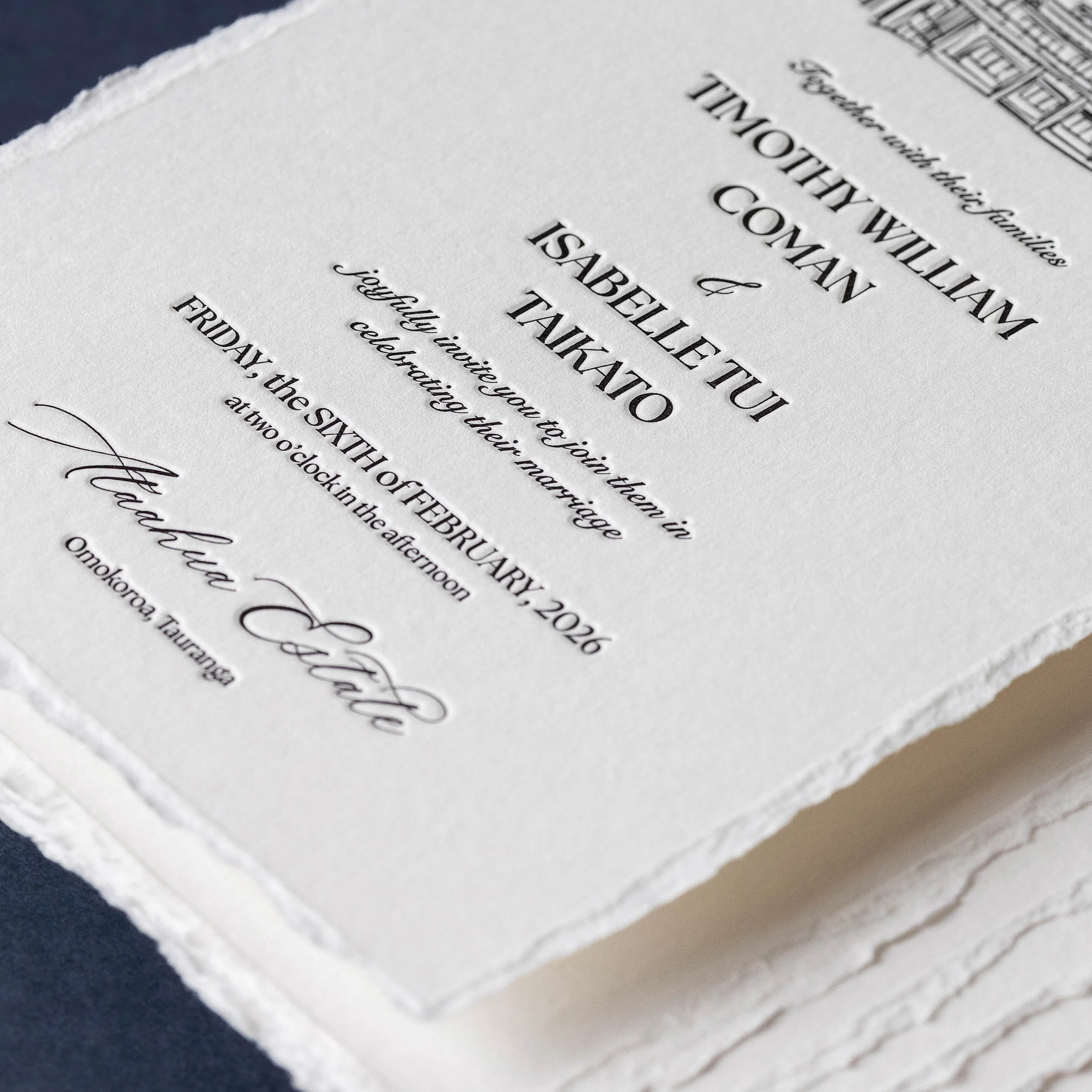 Close-up of a letterpress wedding invitation with crisp black typography and hand-deckled edges.