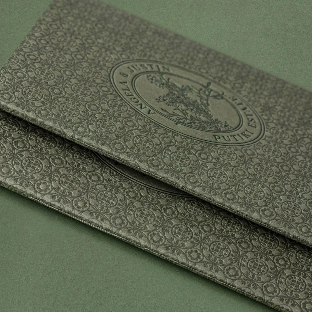 Close-up of Angela and Justin’s letterpress bar menus, featuring the Putiki tile pattern and custom wedding crest.