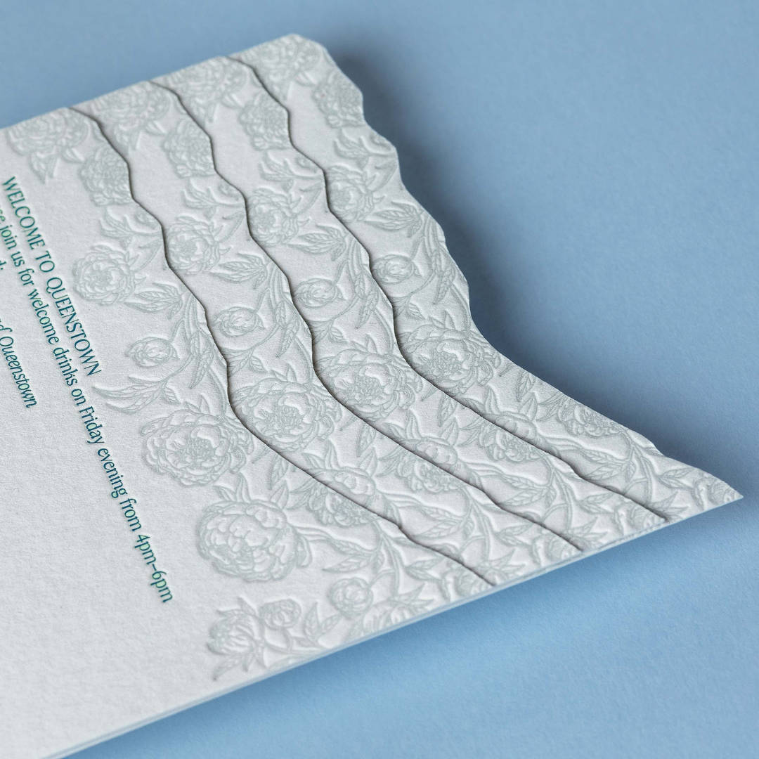 Letterpress details card featuring debossed peonies woven through layered mountain forms, inspired by the landscape at NZ High Country.