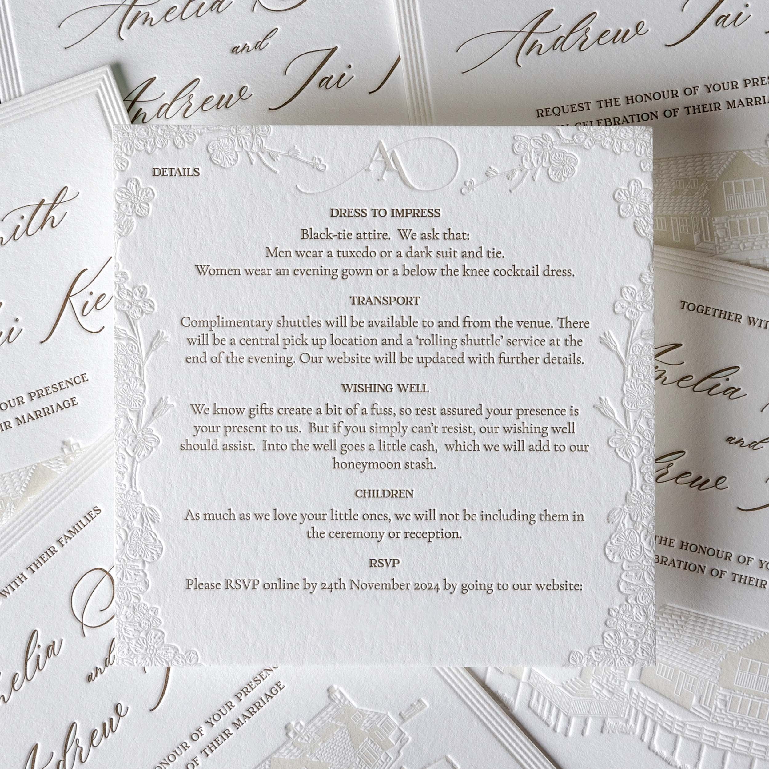Letterpress details card for Amelia and Andrew with a blind deboss floral border and metallic gold typography.
