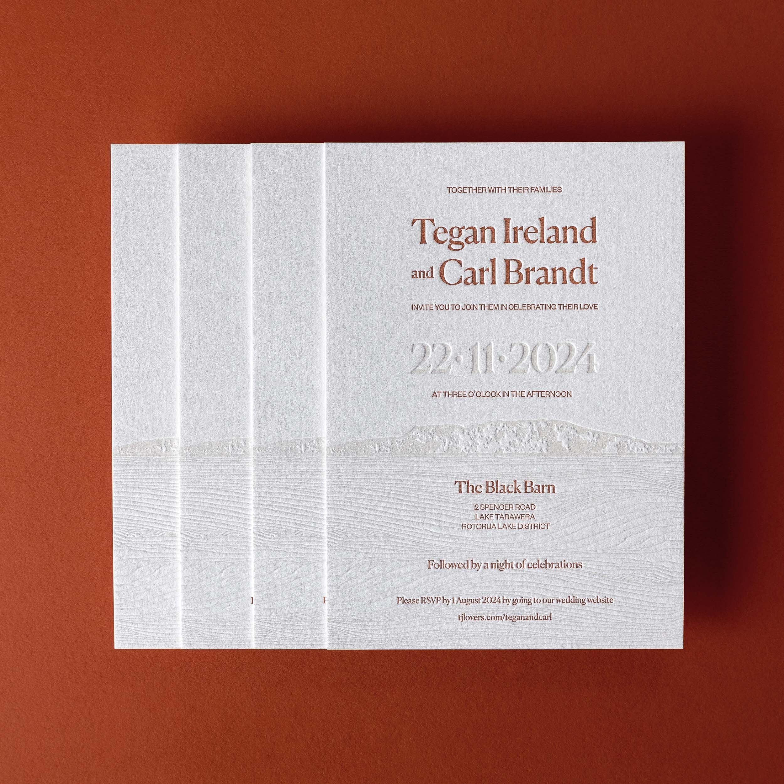 Tegan and Carl's letterpress wedding invitations featuring debossed Mount Tarawera and Lake Tarawera textures.