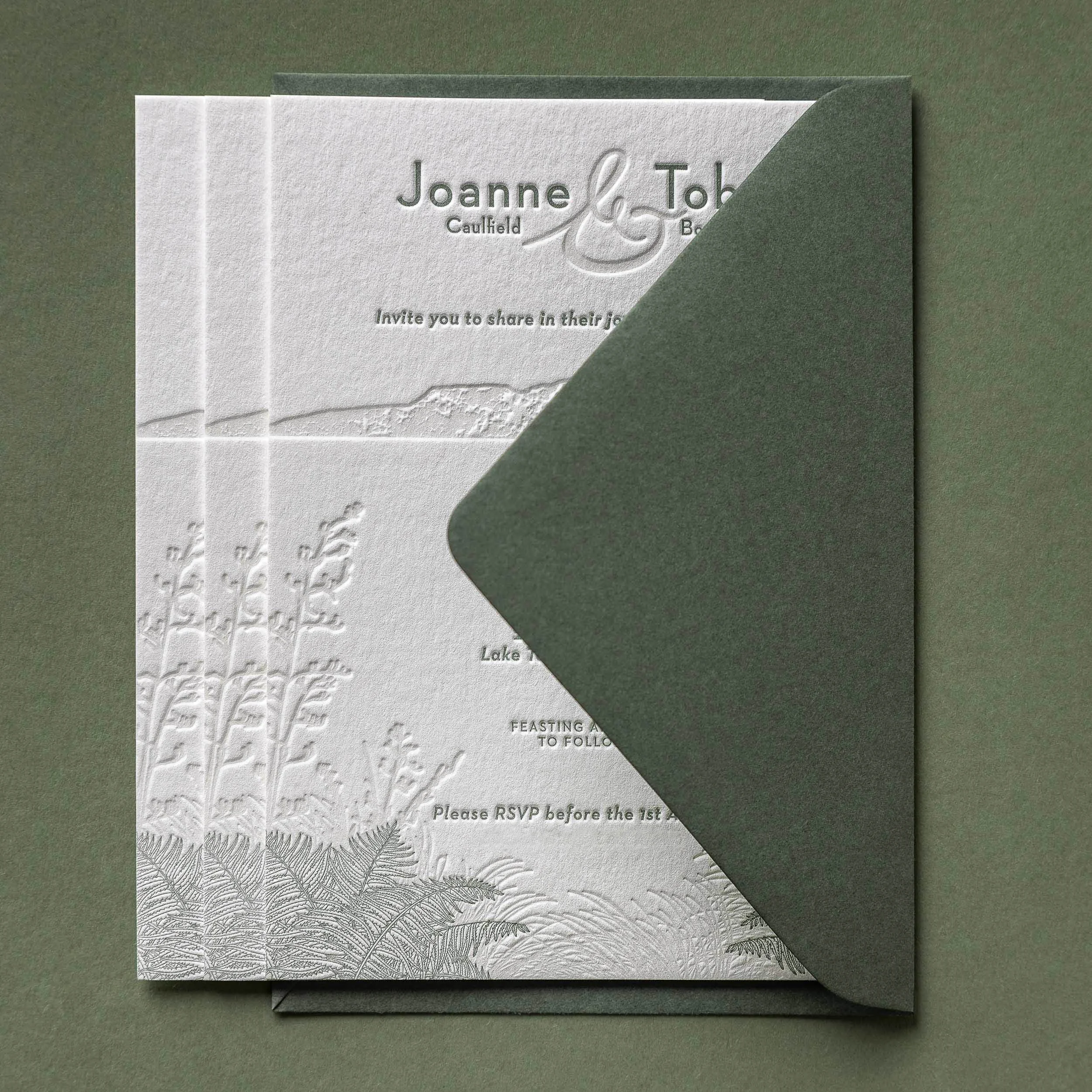Letterpress wedding invitation with olive green envelope featuring Mt Tarawera and native New Zealand flora for a Black Barn wedding.