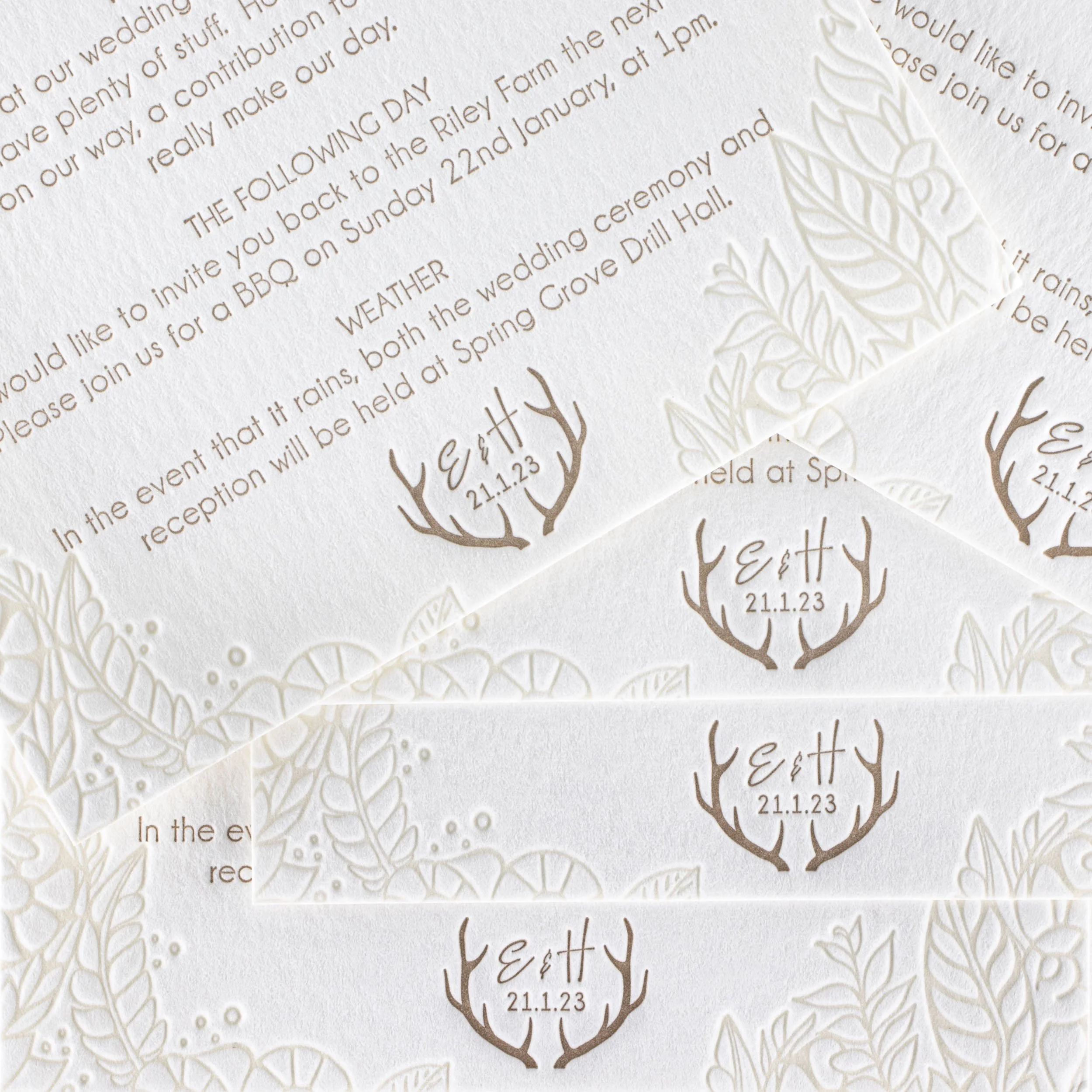 Emma and Hayden’s letterpress wedding details card featuring floral patterns and a personalised gold monogram with their initials, wedding date and deer antlers.