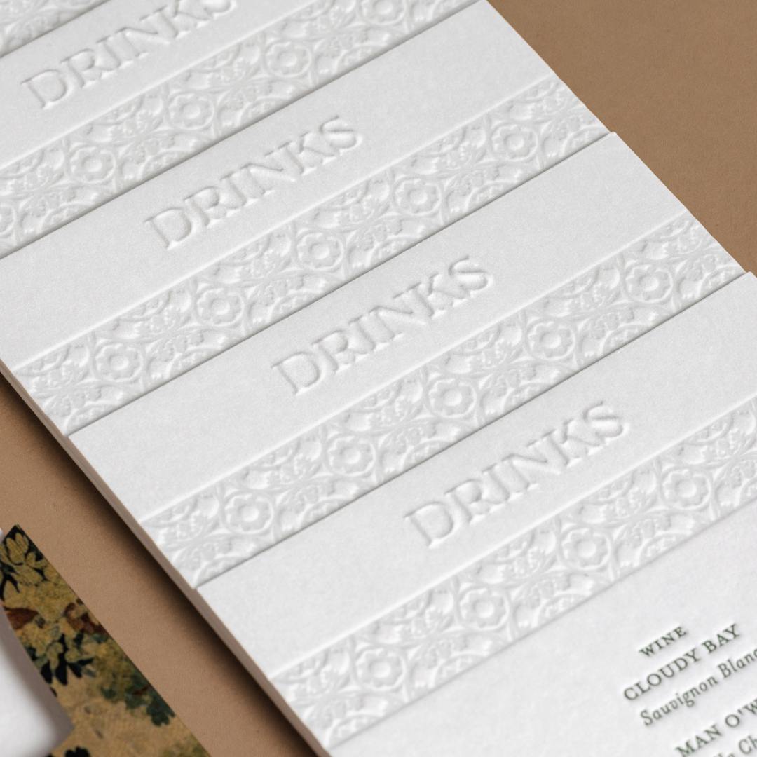 Detail of wedding drinks menus with embossed headings and letterpress Putiki Estate tile pattern.