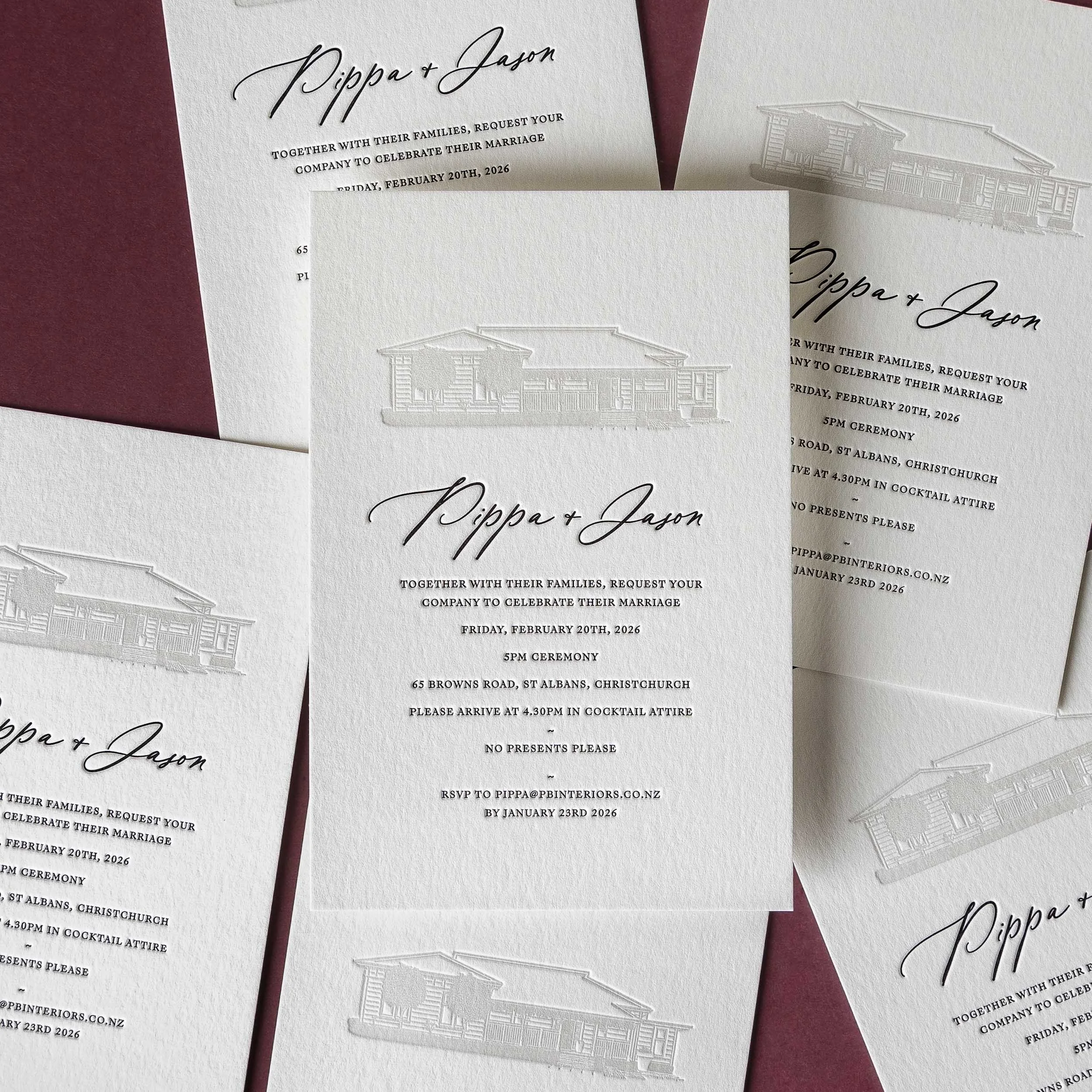 Multiple letterpress wedding invitations featuring an architectural illustration of the couple's home.
