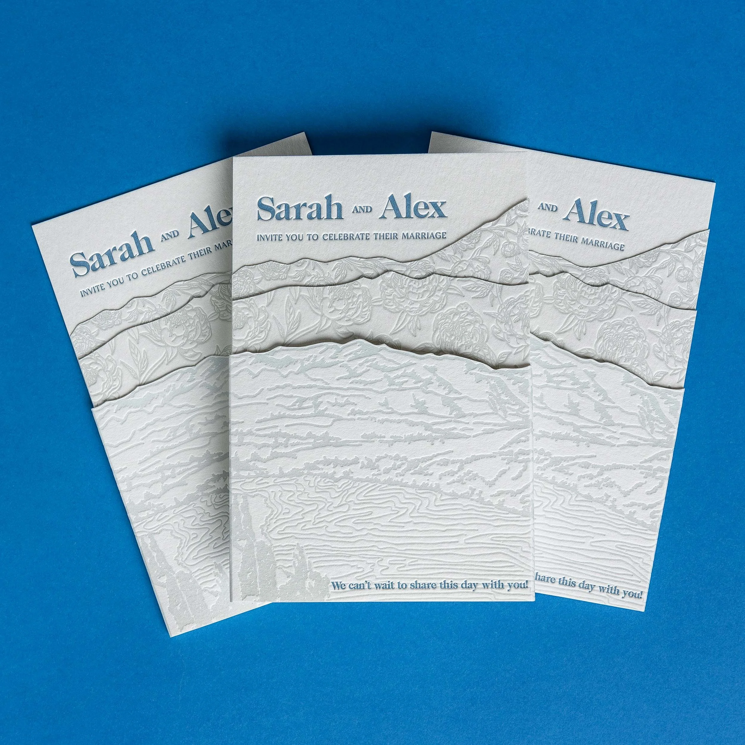 Layered letterpress wedding invitation with a hand-drawn landscape inspired by the view from NZ High Country towards Coronet Peak and debossed peonies.