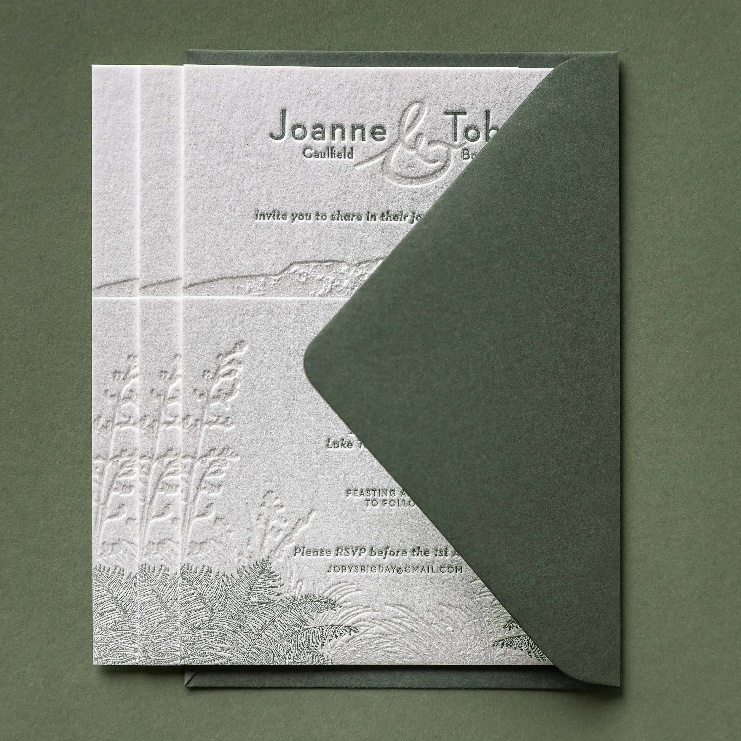 Letterpress wedding invitation with olive green envelope featuring Mt Tarawera and native New Zealand flora for a Black Barn wedding.