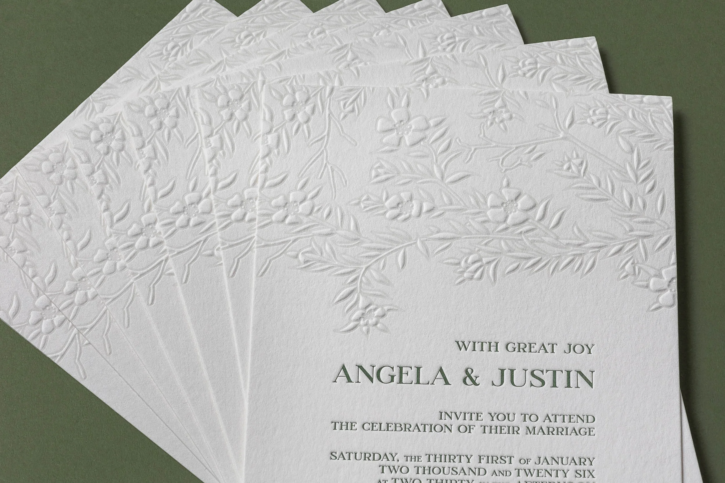 Embossed mānuka botanical detail on a custom letterpress wedding invitation printed on thick cotton paper.