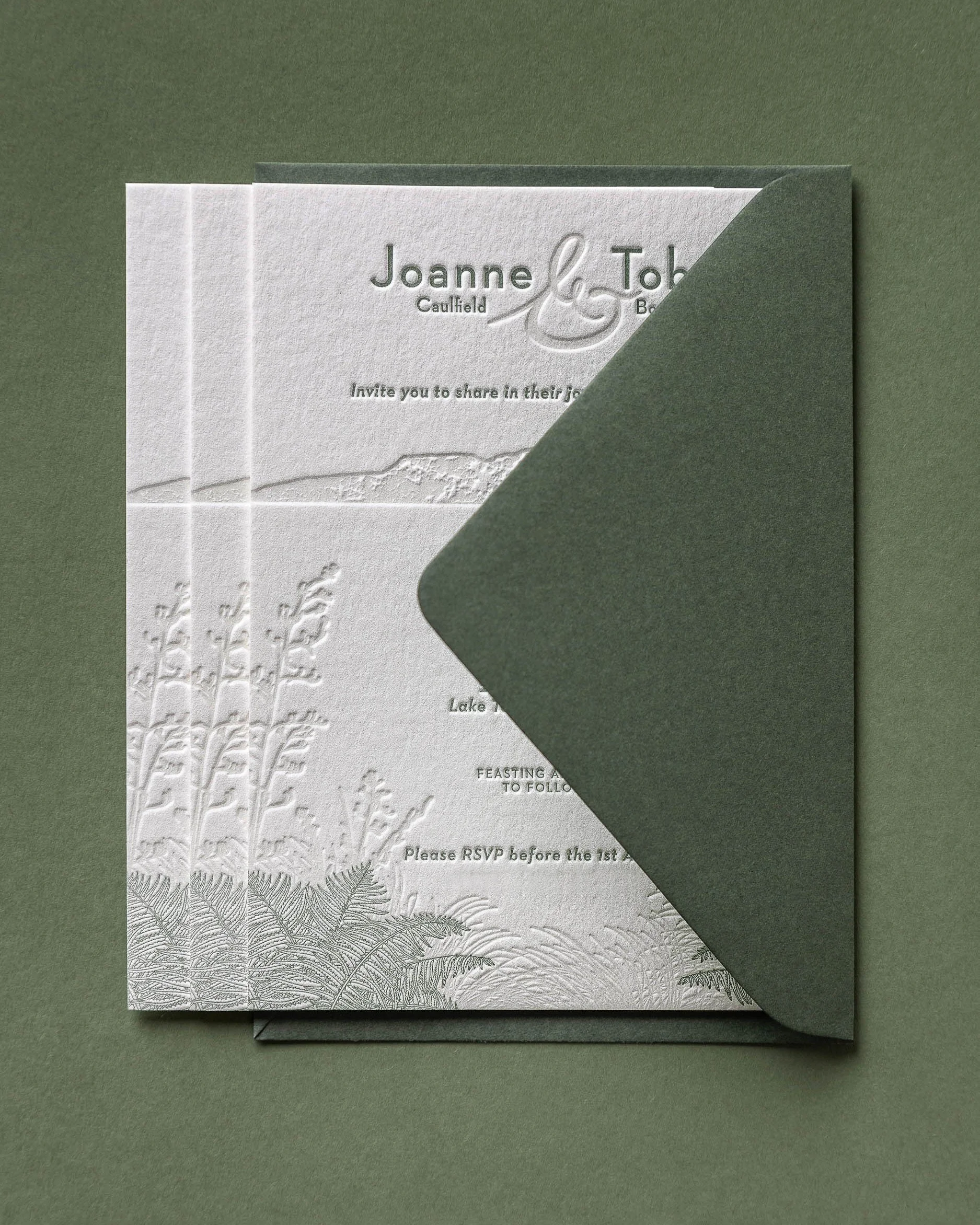Letterpress wedding invitation with olive green envelope, featuring Mt Tarawera and native New Zealand flora for a wedding at The Black Barn.