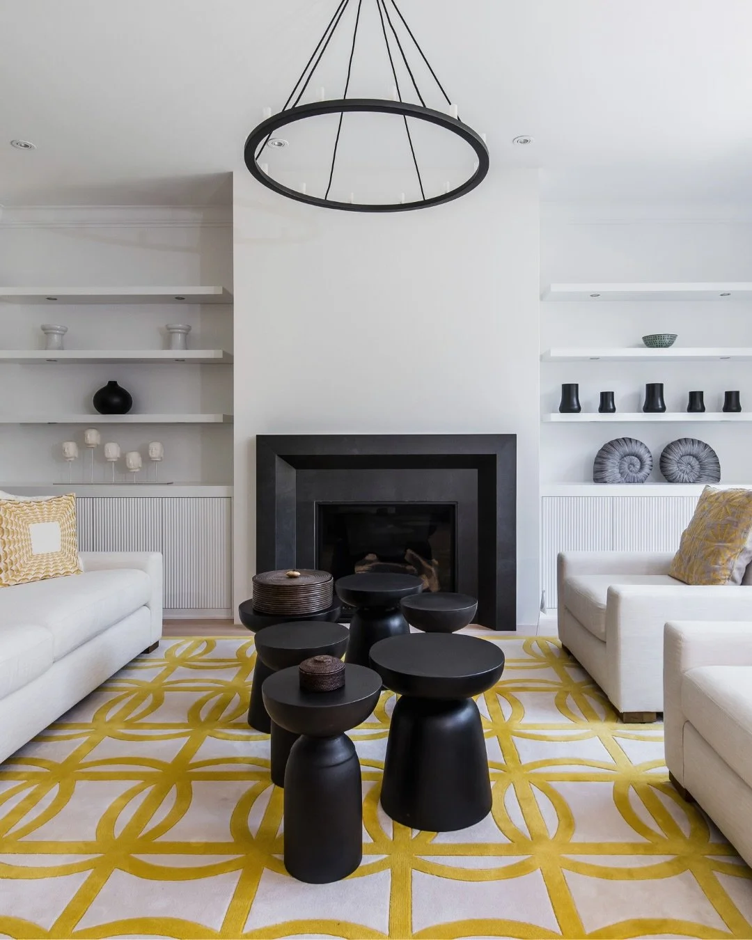 Project Gloucester: The black fireplace anchors the room with quiet presence, while the yellow carpet spreads warmth and spontaneity underfoot. Minimal lines allow light to travel freely, shaping moments of pause and reflection. This living room is m