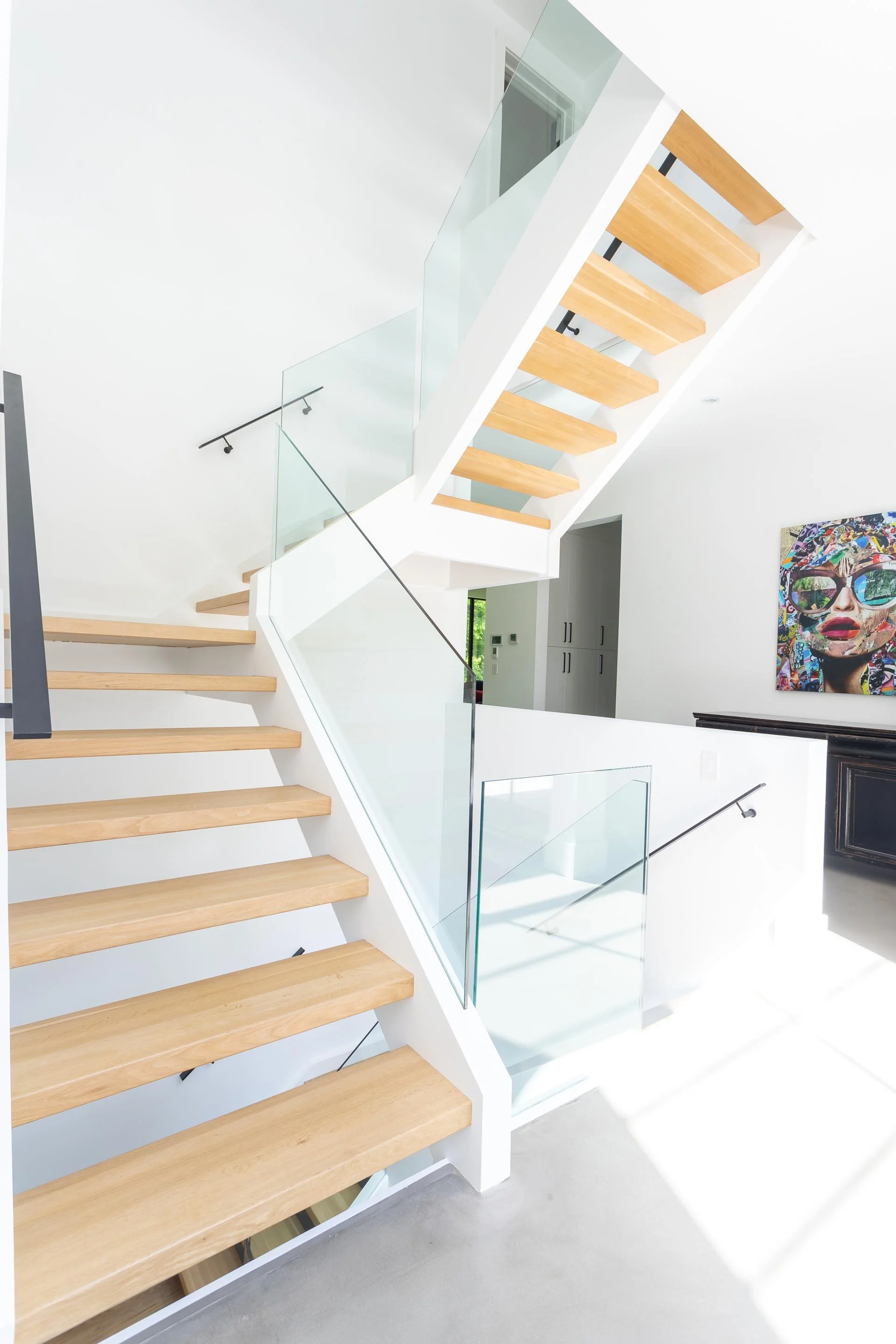 Luxury staircase design in Burlington custom home by architecture firm, featuring modern detailing, refined materials and clean architectural lines