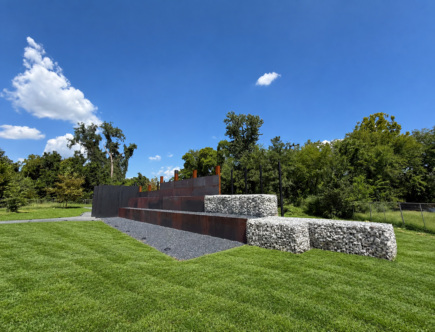 Rendering of a memorial wall installation featuring engraved names and historical imagery, with visitors interacting with the display. Highlights storytelling, cultural memory, and the role of design in honoring the past.