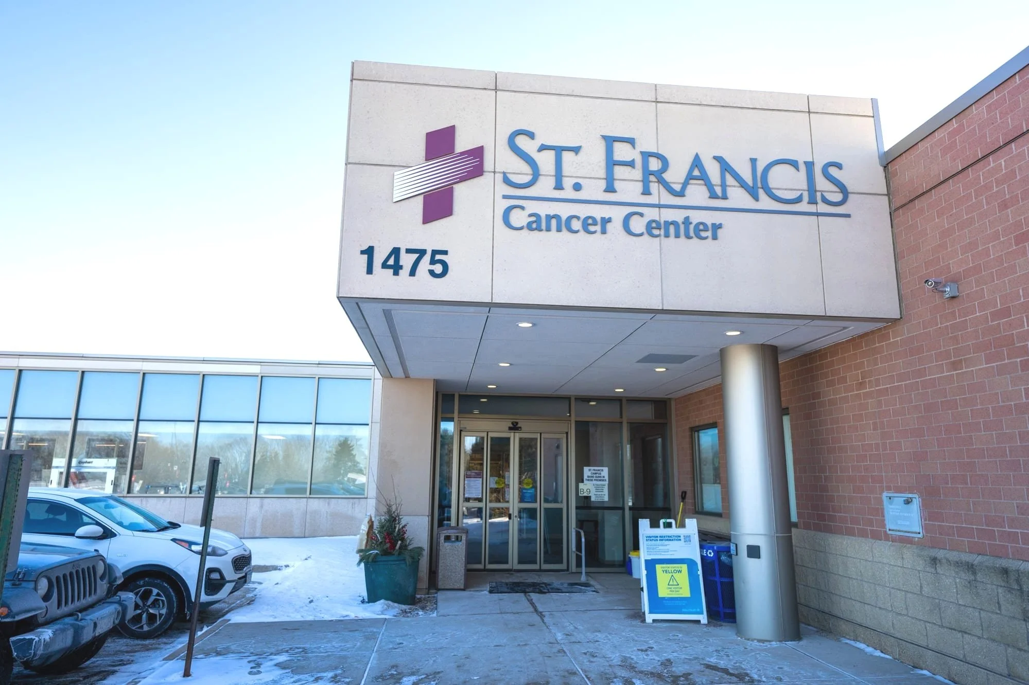 Entrance to St. Francis Cancer Center with signage, automatic glass doors, and accessibility features. Emphasizes welcoming access to specialized care and a commitment to community health services.