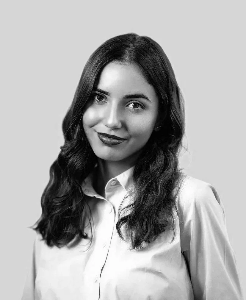 Portræt af en kvinde i lyseblå skjorte på en neutral baggrund.