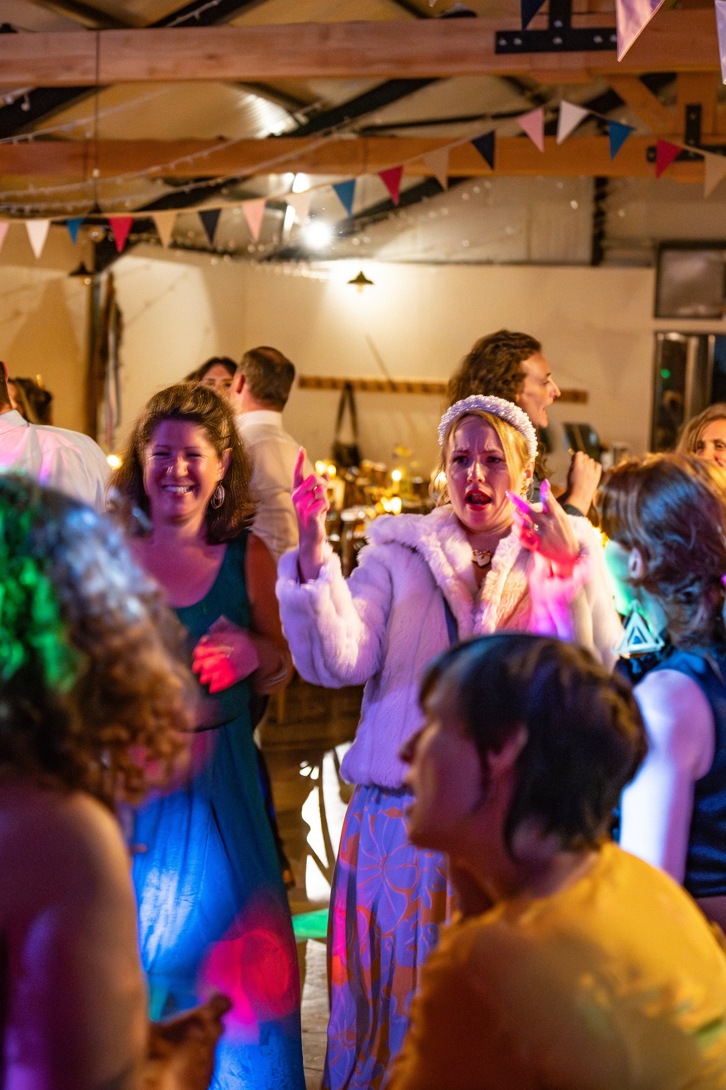 Group of people dancing and socializing at a party or celebration in a decorated indoor venue.