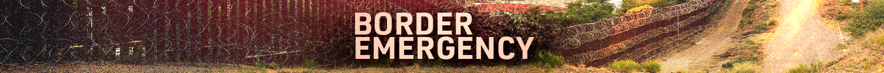 Barbed wire fence along the border with a sign that says 'Border Emergency'