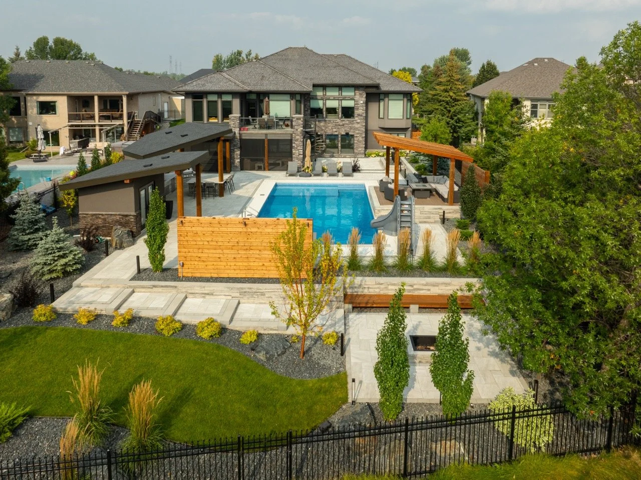 Backyard with modern house, swimming pool, landscaped garden, patio area, and pergola.