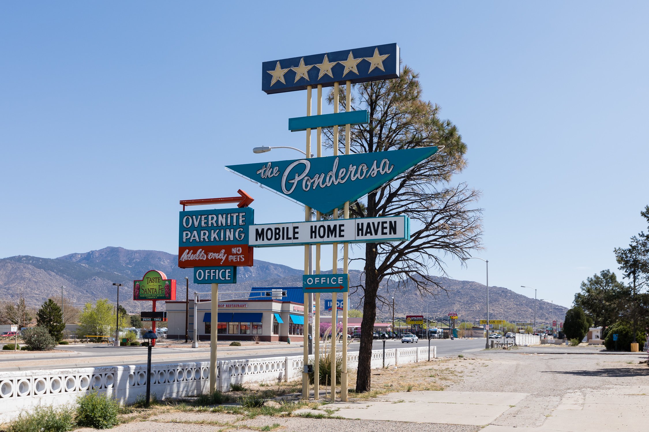 Cartel de neón del motel Ponderosa con montañas al fondo