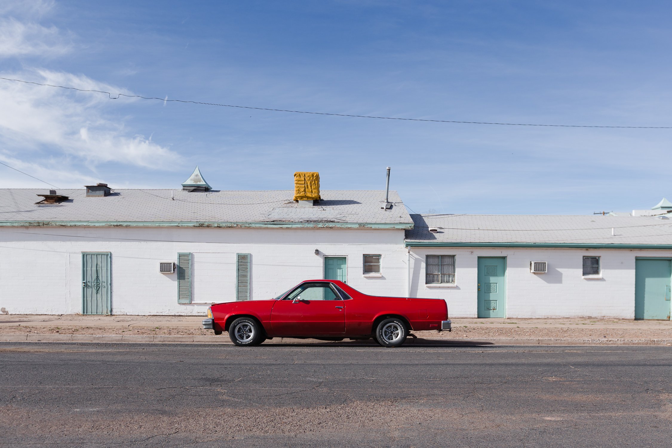 Auto rojo frente a un motel de ruta en Estados Unidos