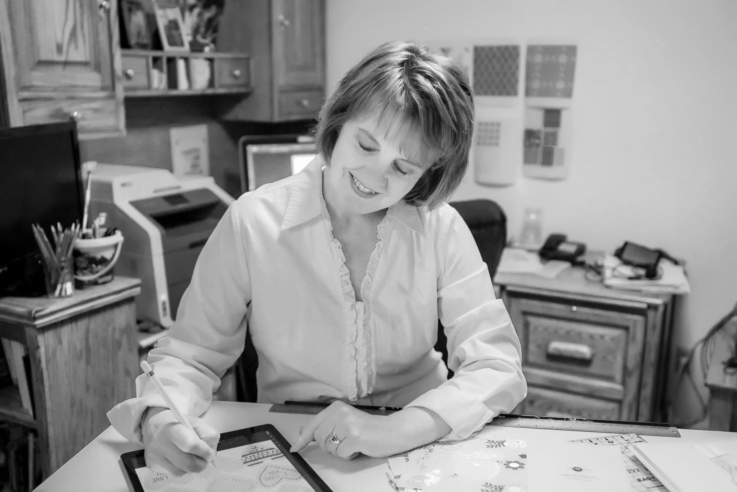Woman smiling looking down as she creates digital art