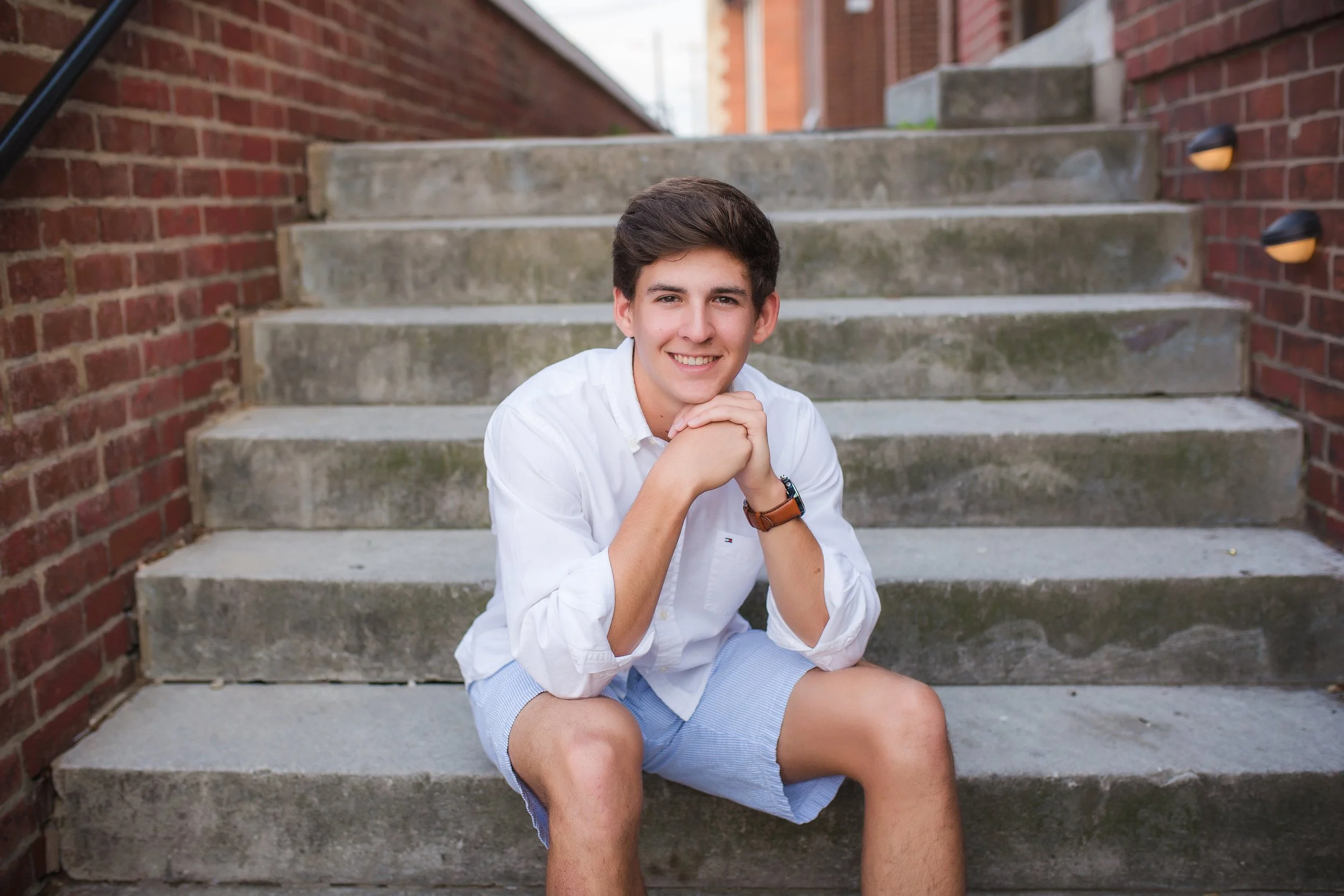 High school young man sitting on steps