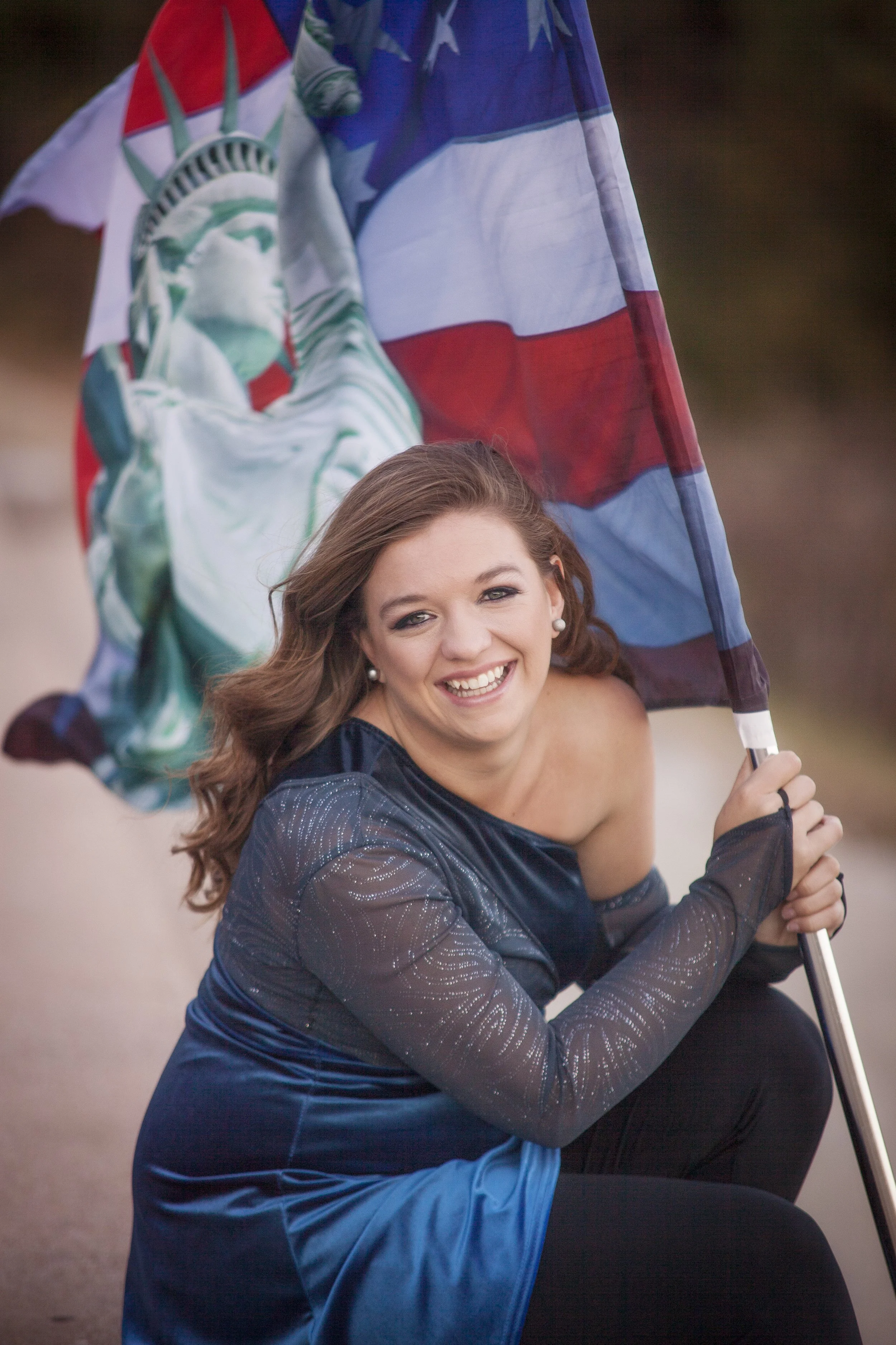 high school senior portrait of girl in uniform with color guard flag
