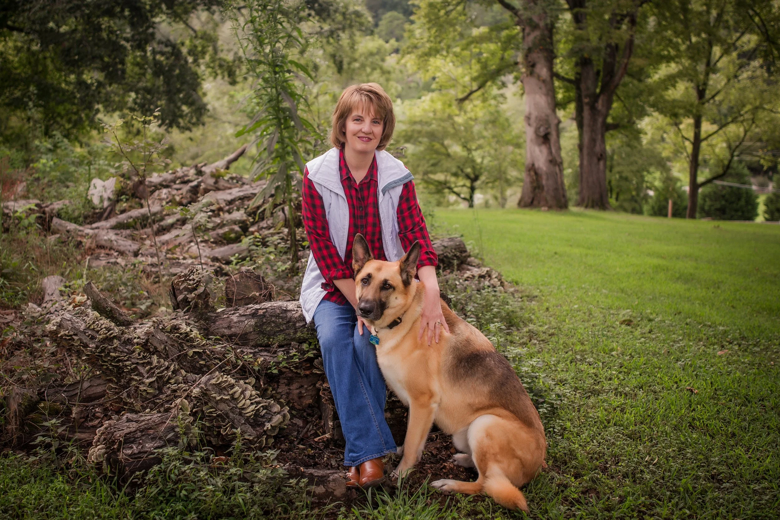 Woman and german shepard sitting outside smiling