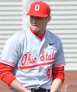 A young male baseball player wearing a white Ohio State uniform with red accents and a red cap with a white O logo.