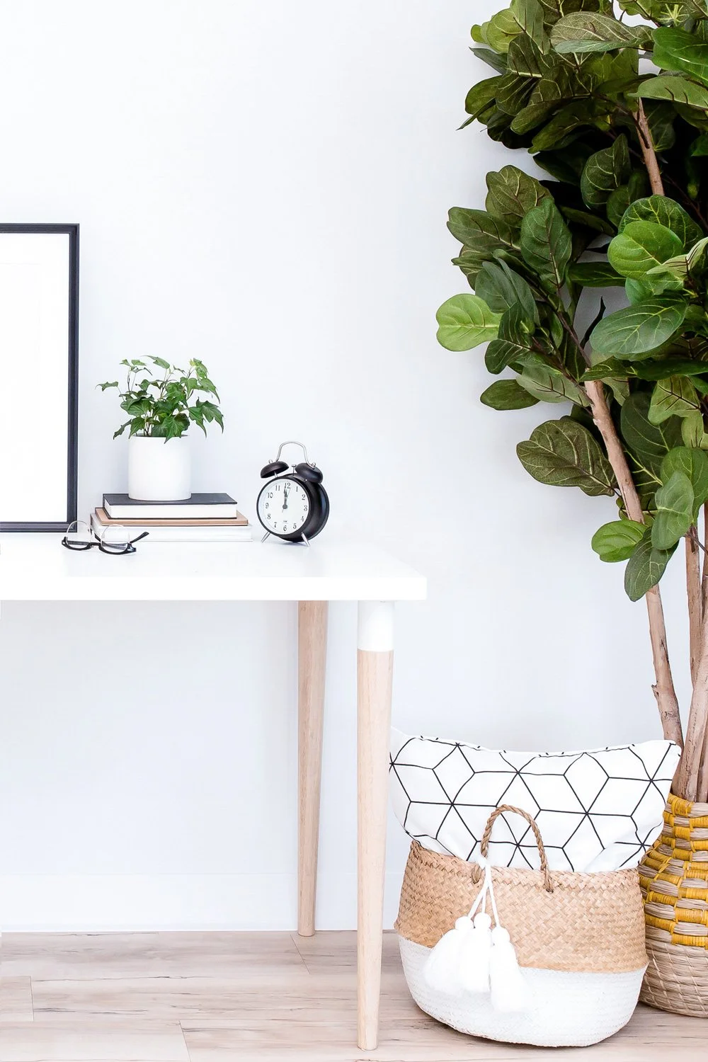 Modern office setting with a stylish pillow, white desk, and tall plant, showcasing SmallBiz Sidekick's flair for creating inviting and productive workspaces for Squarespace website designers