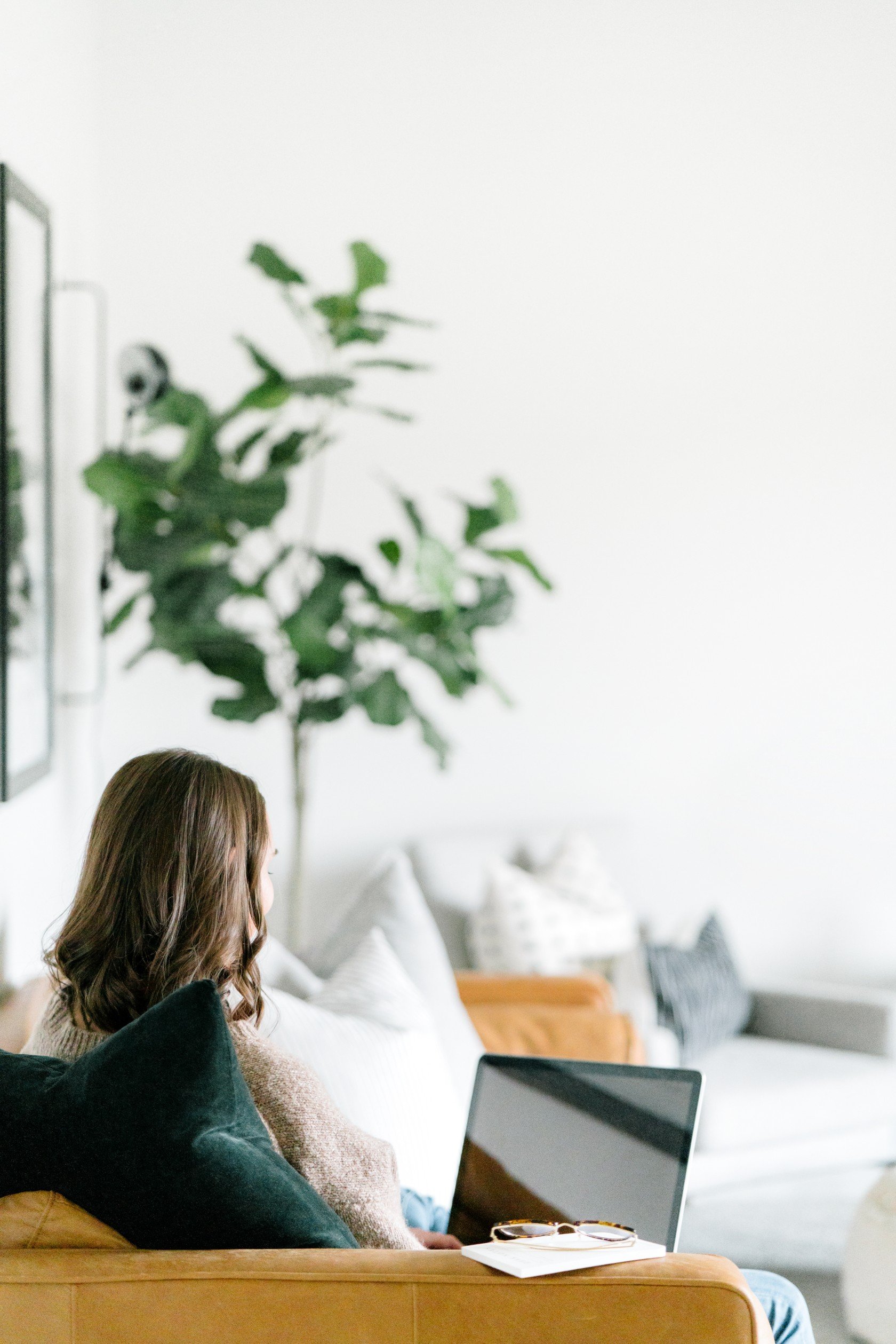 Woman sitting on couch looking at computer