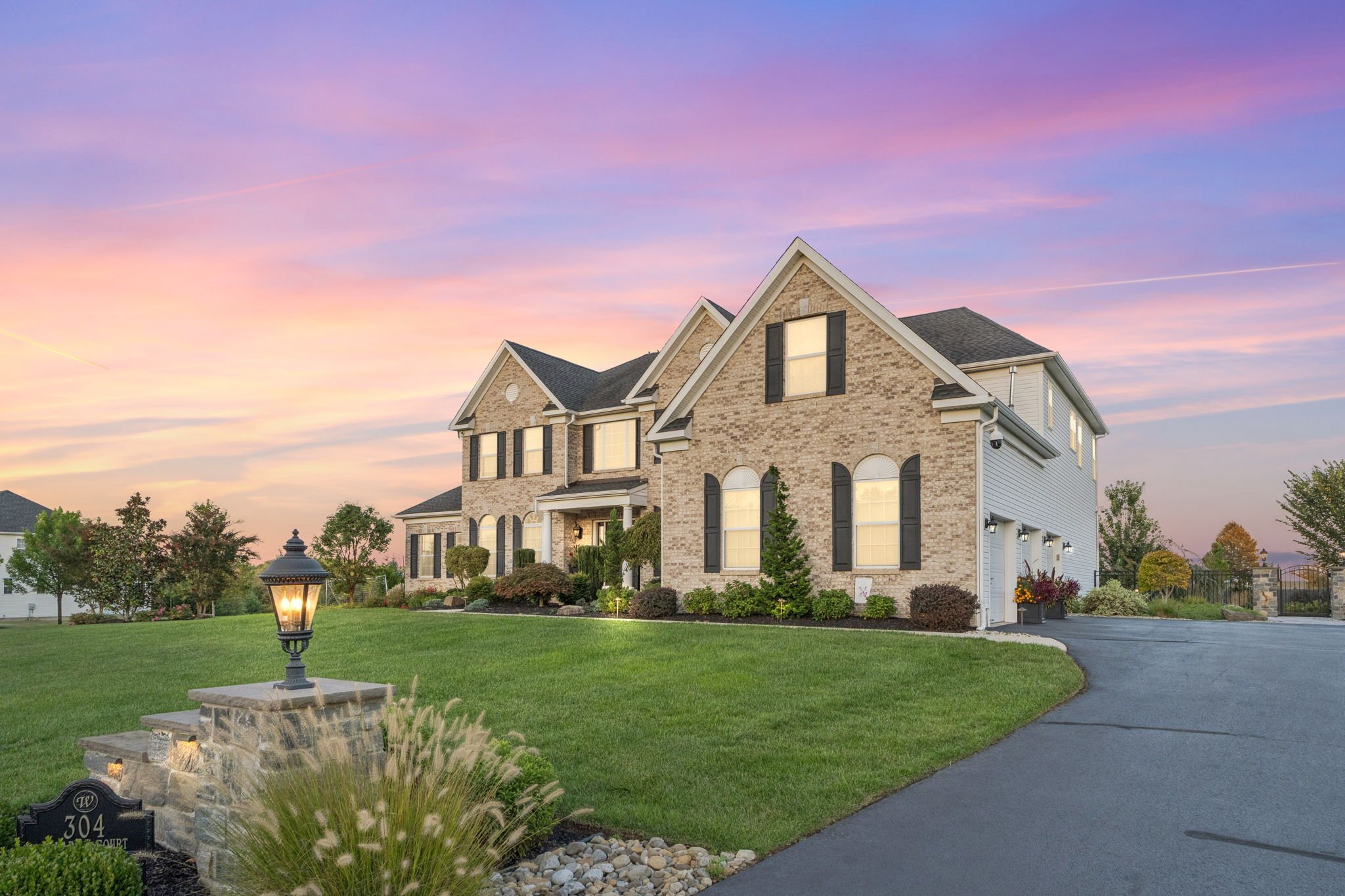 Brick and stone front of the home at twilight under a pink and purple sky
