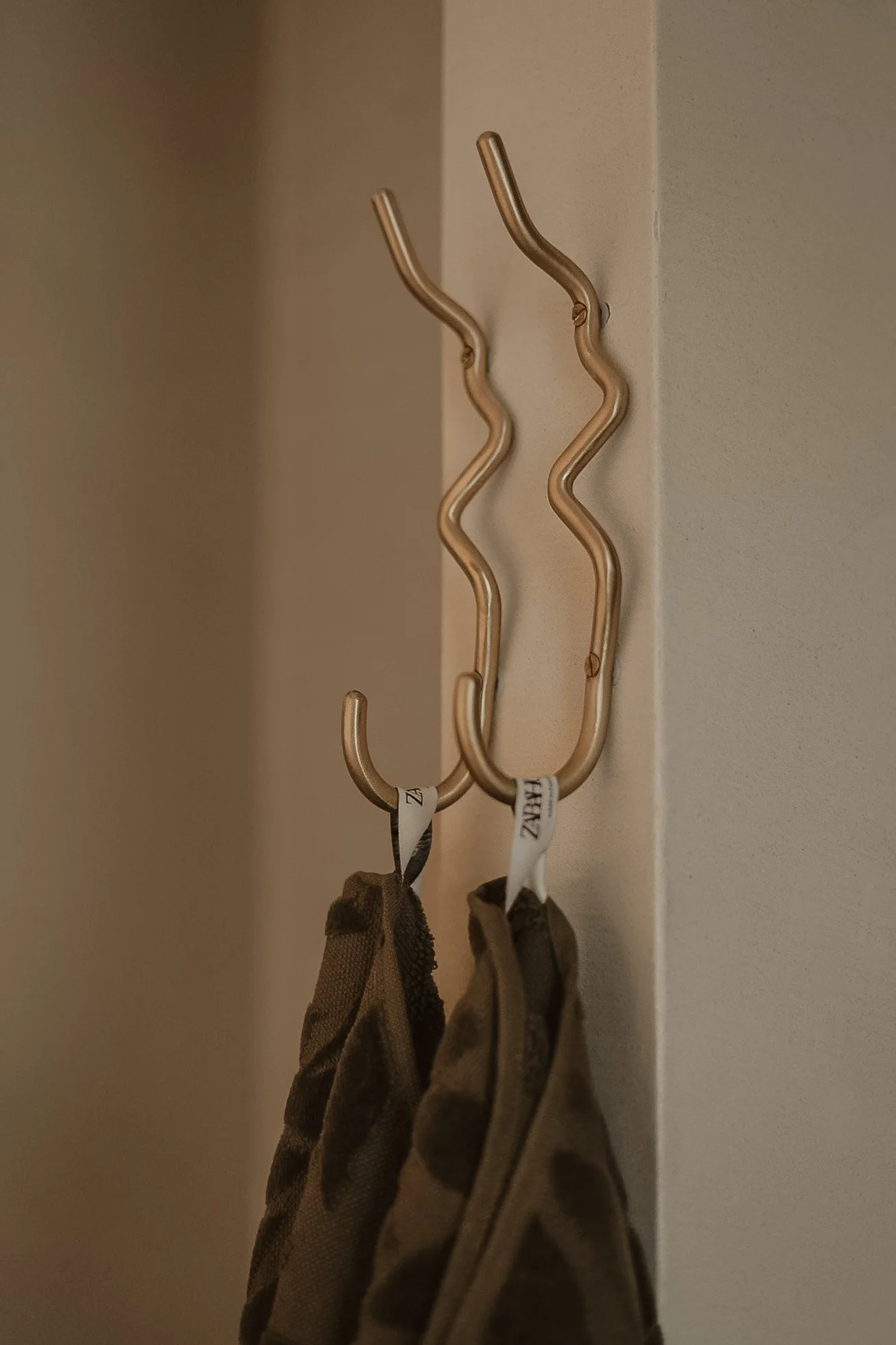 Twee zachte kapotte hangers hangen aan een muurhaak.