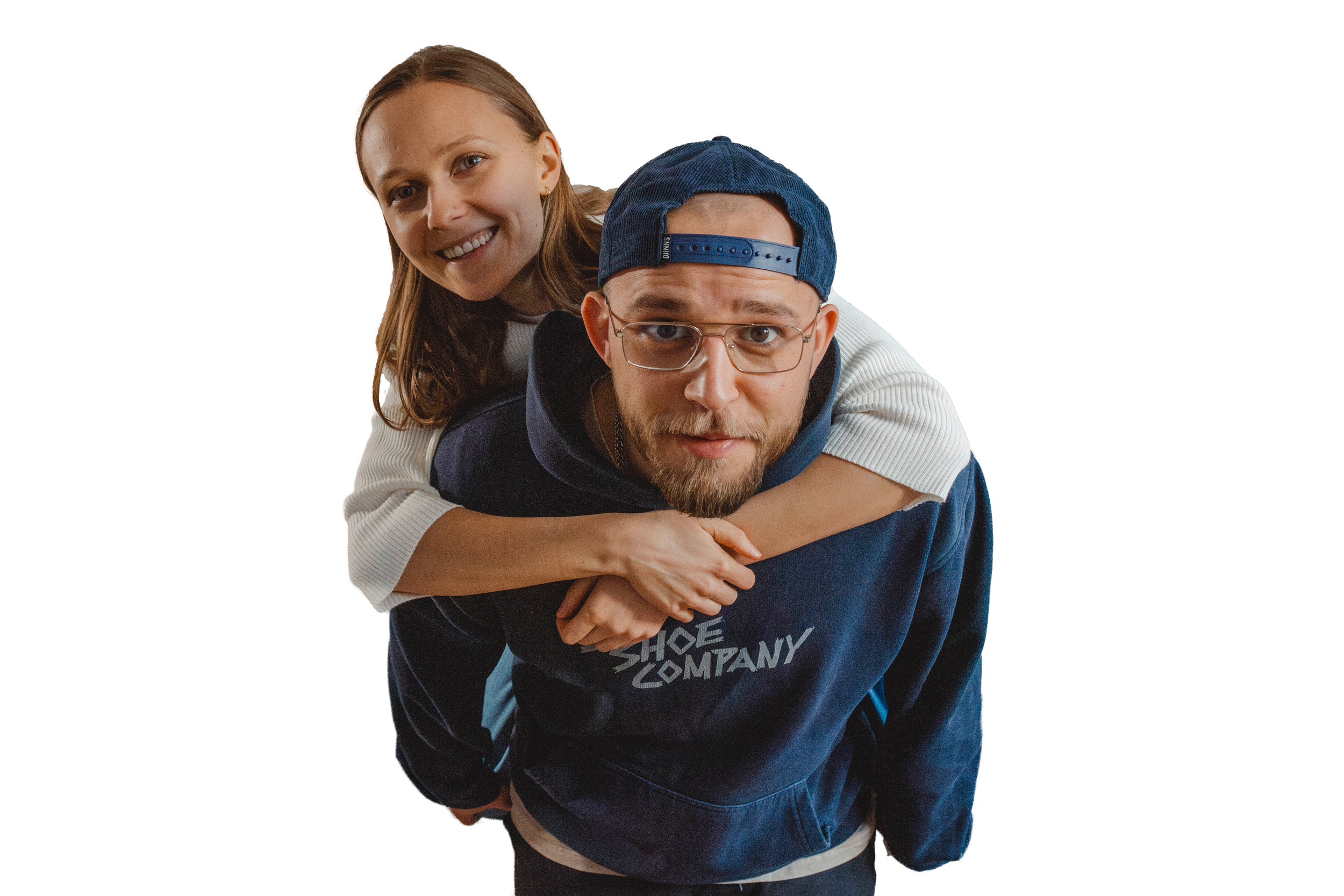 Die beiden Fotografen Julia und Pady schauen fröhlich in die Kamera. Pady trägt Julia auf dem Rücken.