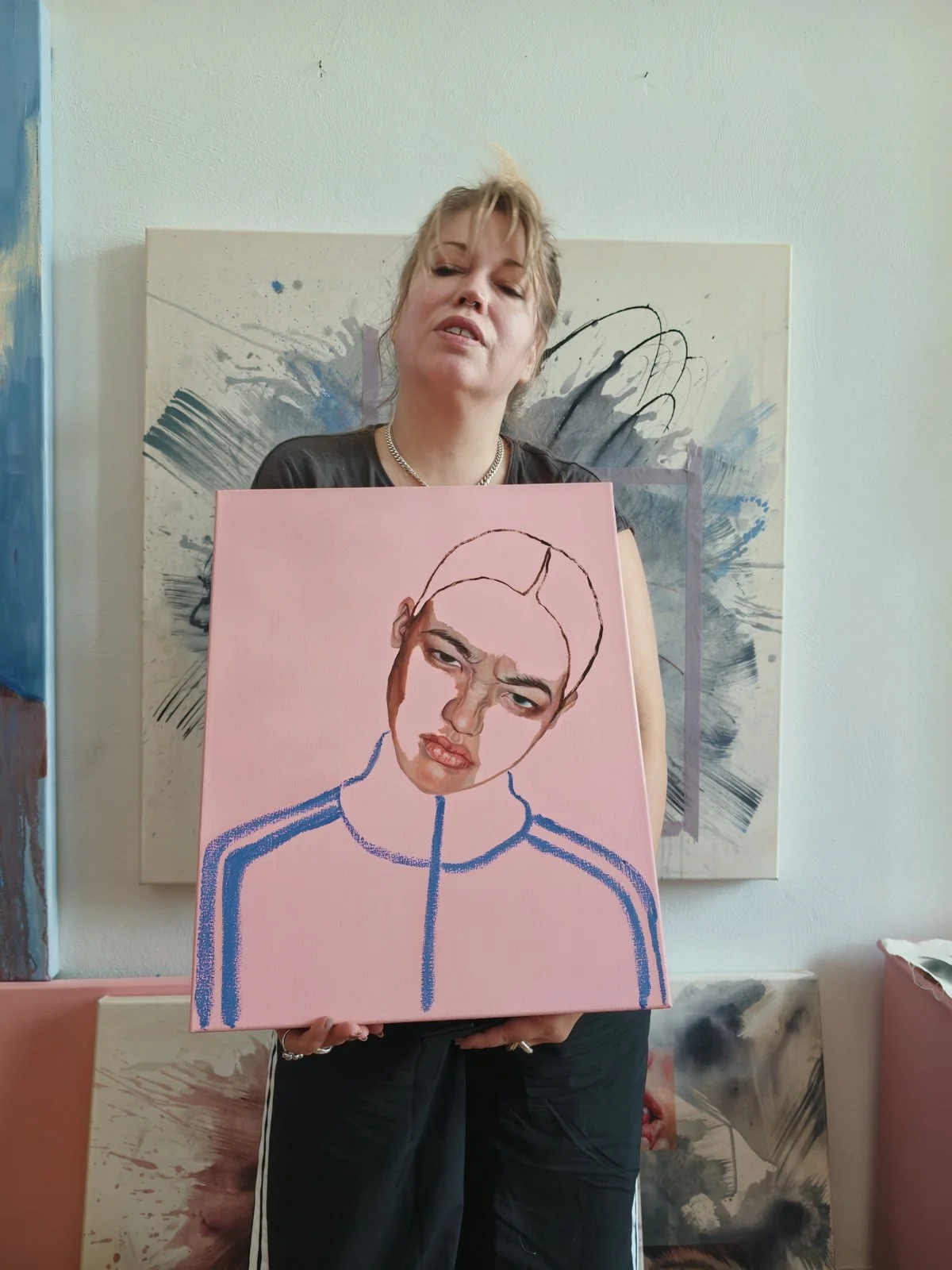 Jette Leder holding her painting Training Season XVI in her Berlin studio