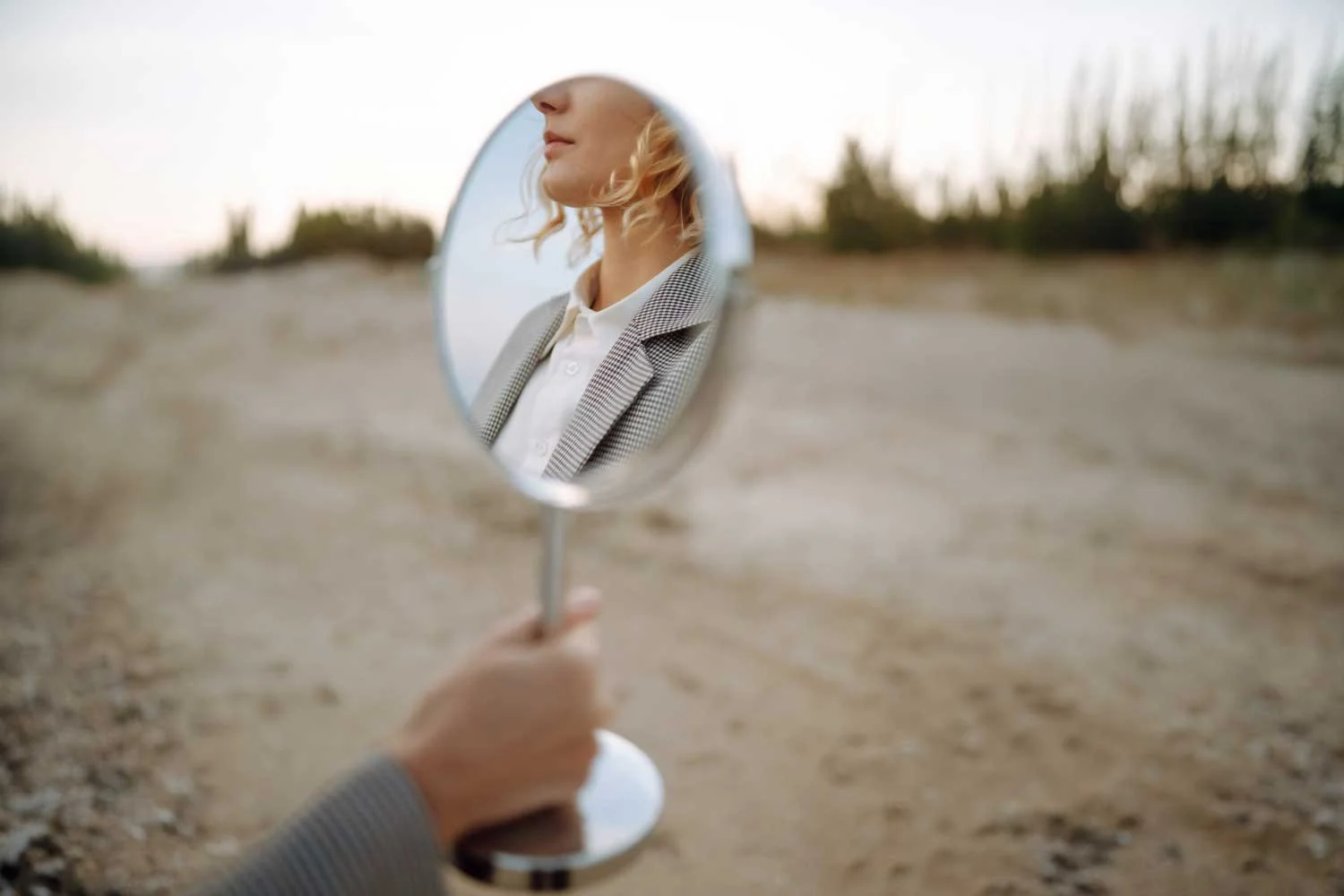model posing with mirror on a beach