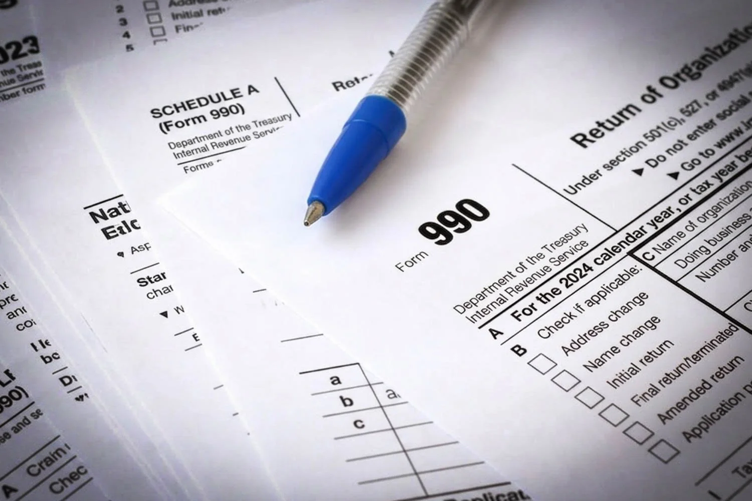 Pen, IRS form 990, and other forms scattered