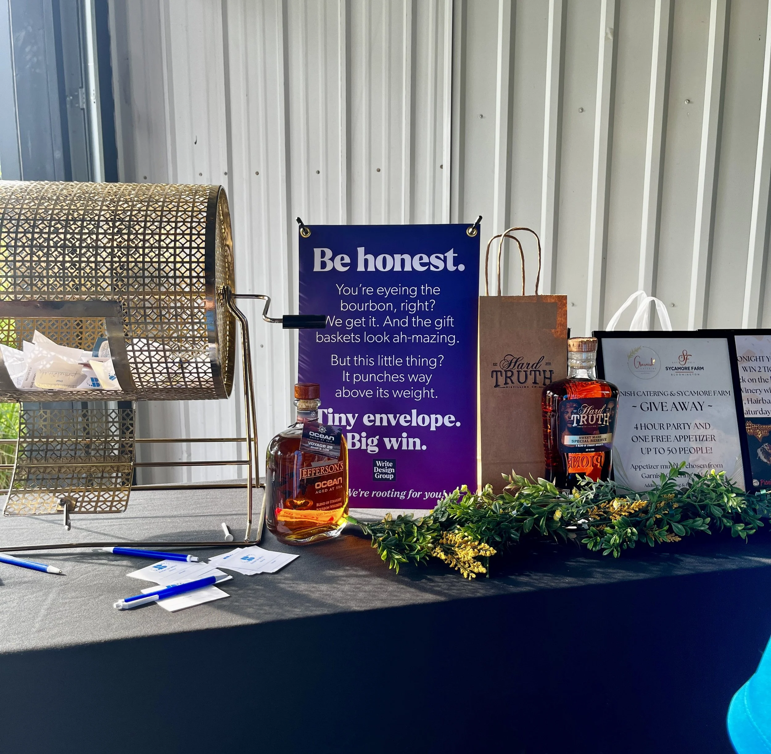 Branded sign sitting on prize table surrounded by booze