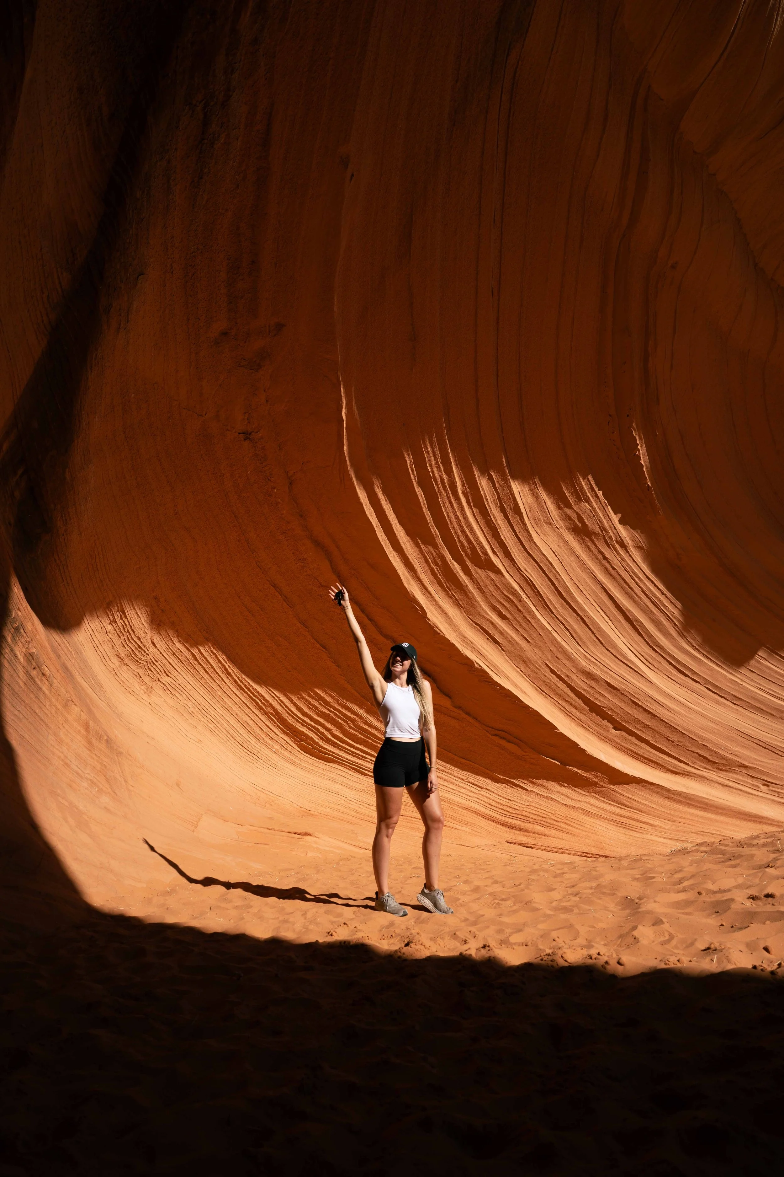 Woman standing inside a red rock canyon, representing balance, movement, and outdoor wellness in Arizona.